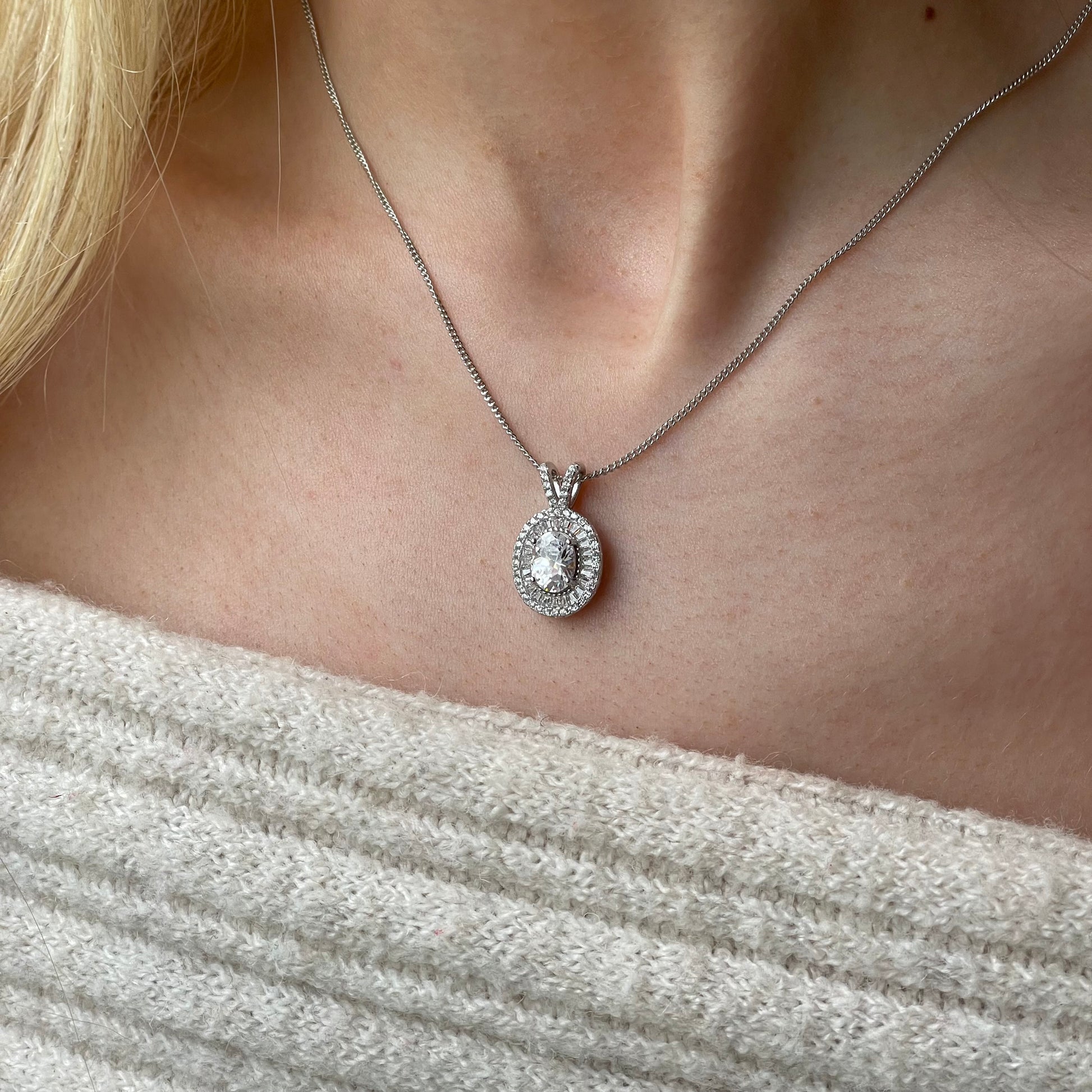 Silver oval CZ halo necklace featuring a central cubic zirconia stone with a delicate chain, by Insignia.