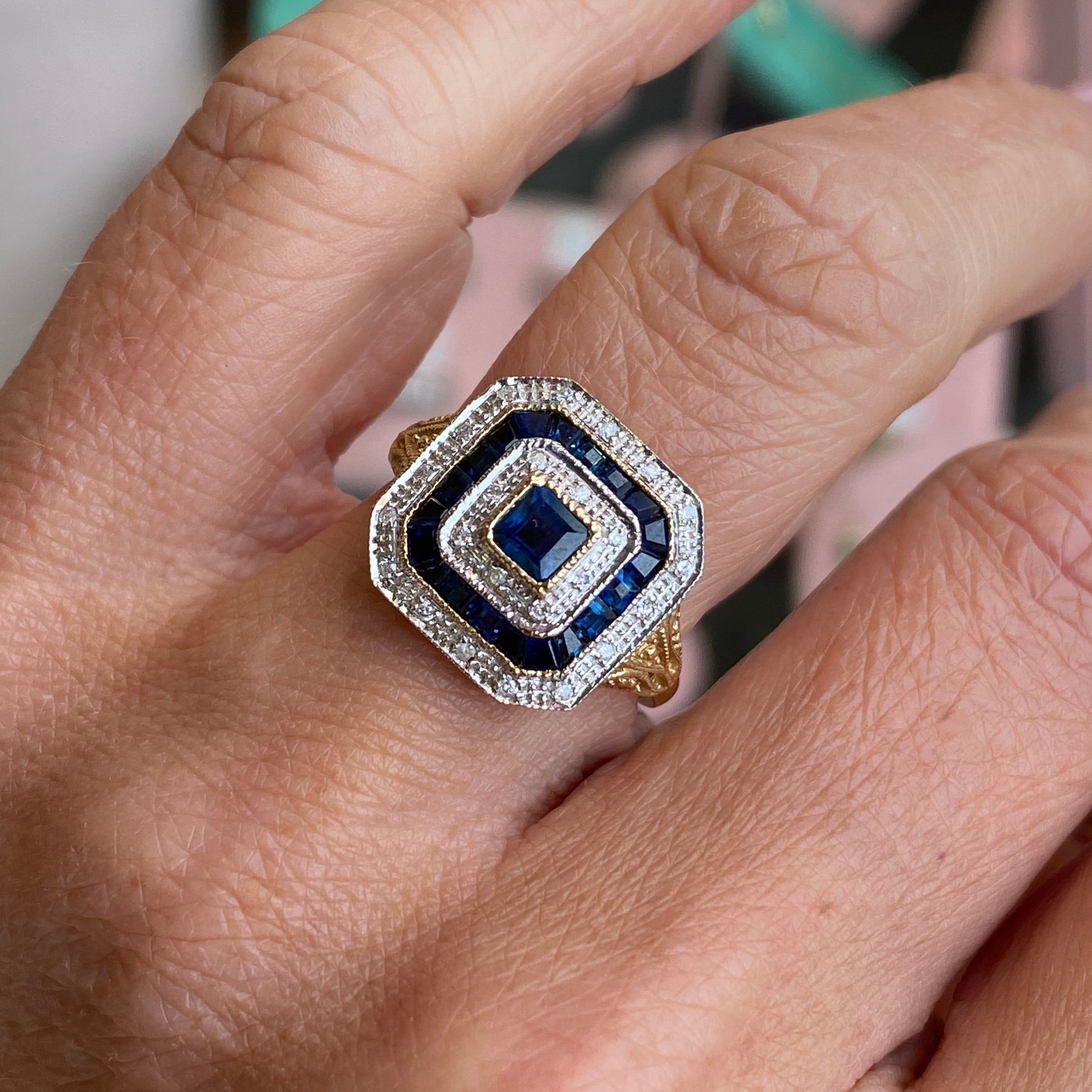 9ct gold sapphire and diamond ring by Luke Stockley, featuring a central sapphire gemstone surrounded by sparkling diamonds.