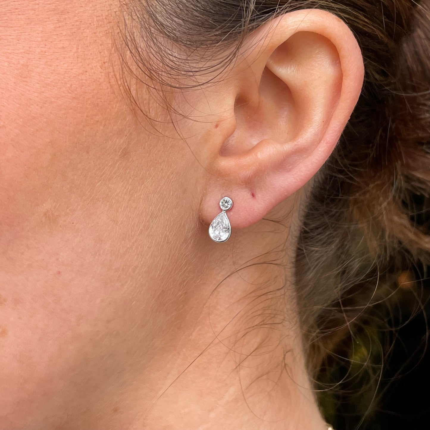 Mark Milton 9ct white gold pear and round cubic zirconia stud earrings with rubover setting, showcasing elegant jewelry design.