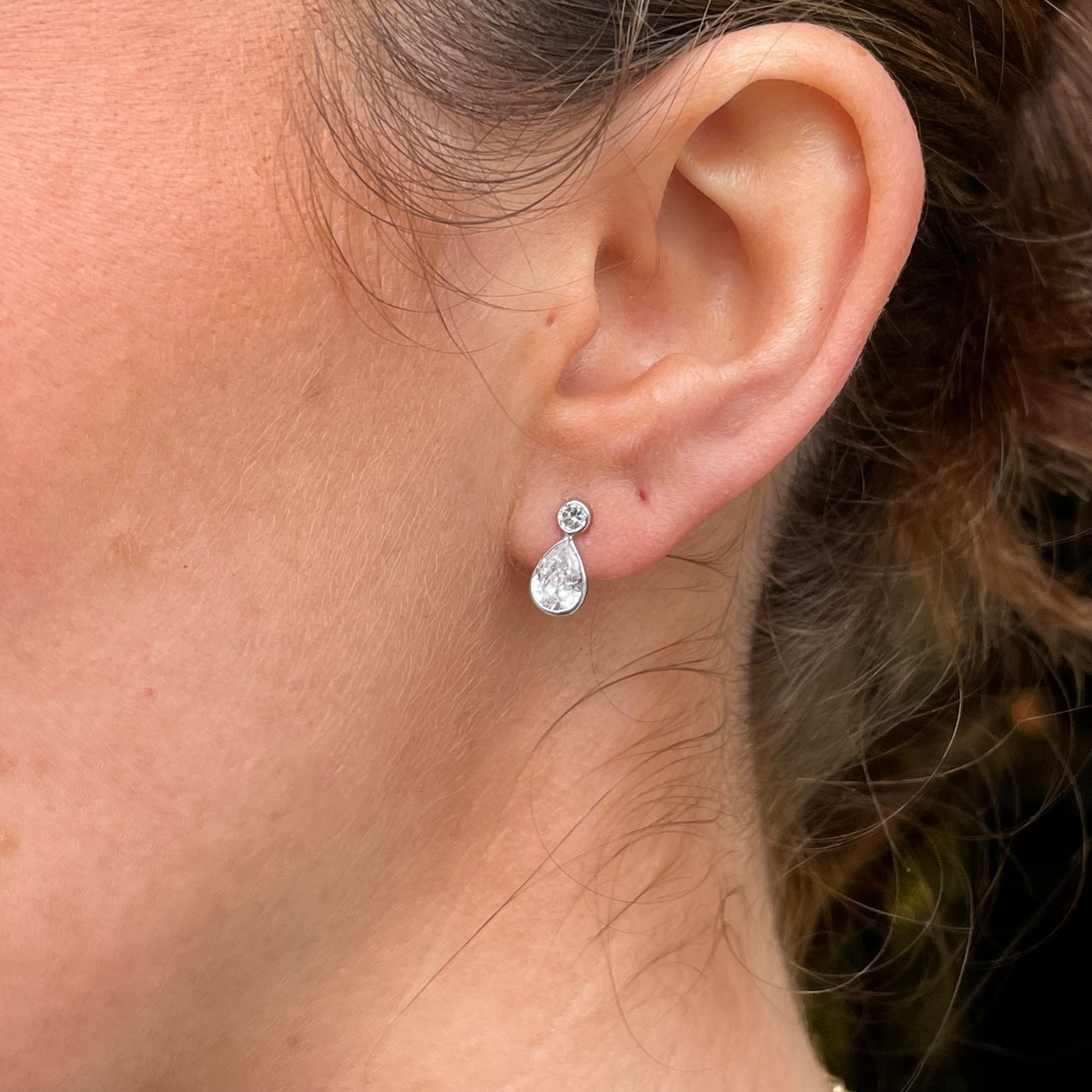 Mark Milton 9ct white gold pear and round cubic zirconia stud earrings with rubover setting, showcasing elegant jewelry design.