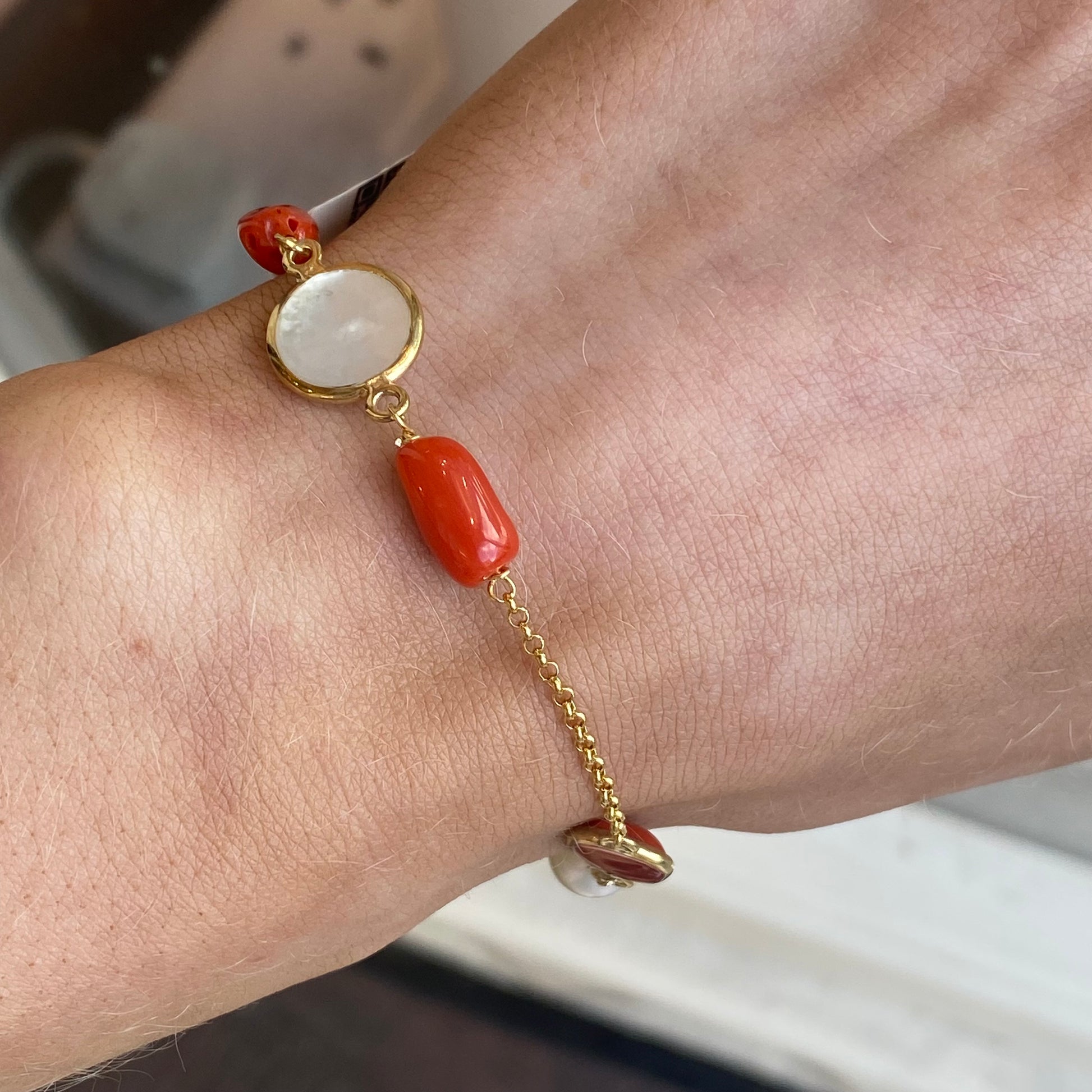 Bruno coral, pearl, and mother of pearl bracelet featuring mixed beads and elegant design on a white background.