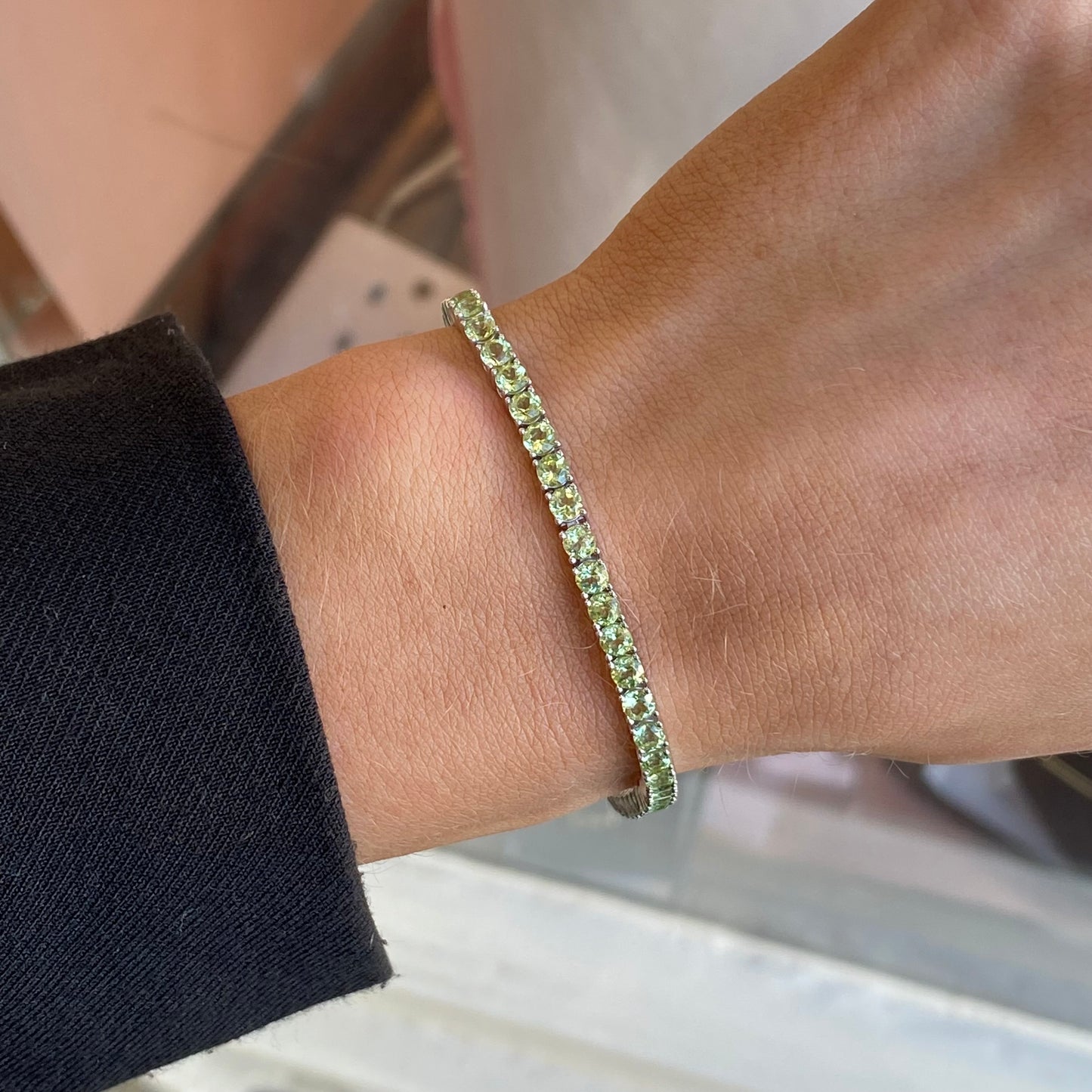 Silver Claw Set Peridot Tennis Bracelet by Insignia featuring silver links with peridot gemstone accents.