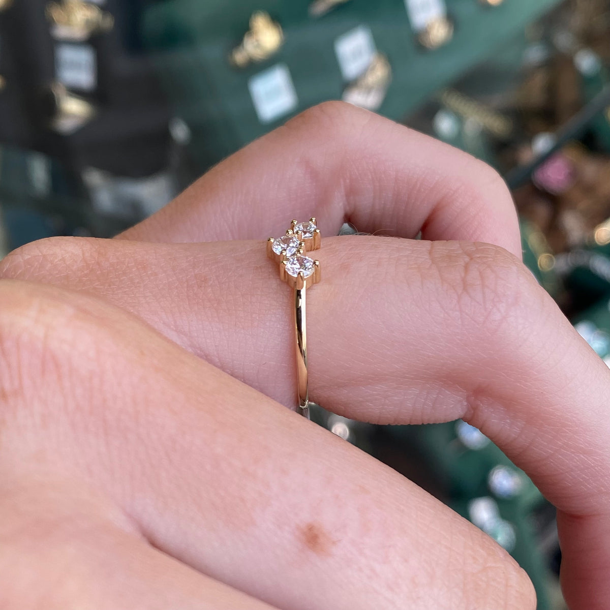 9ct gold CZ trilogy wishbone ring with three sparkling stones, crafted by NJO, shown from a side angle highlighting its elegant design.