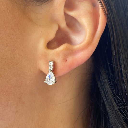 Silver CZ pear drop earrings by Insignia featuring elegant teardrop-shaped cubic zirconia stones and silver-tone hooks.