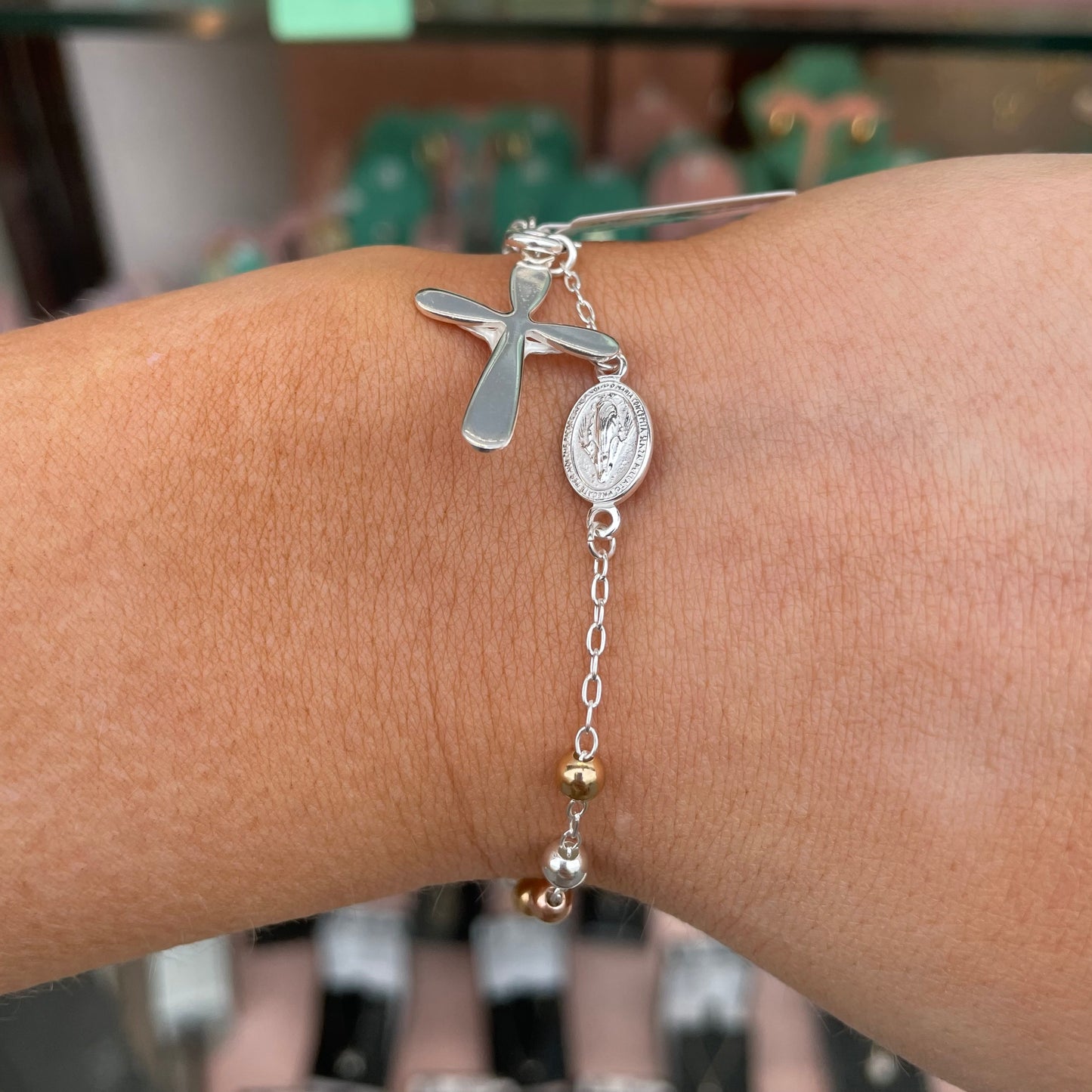 Silver rosary bracelet by Kurate featuring delicate beads and a cross charm, elegant jewelry accessory for spiritual or stylish wear.