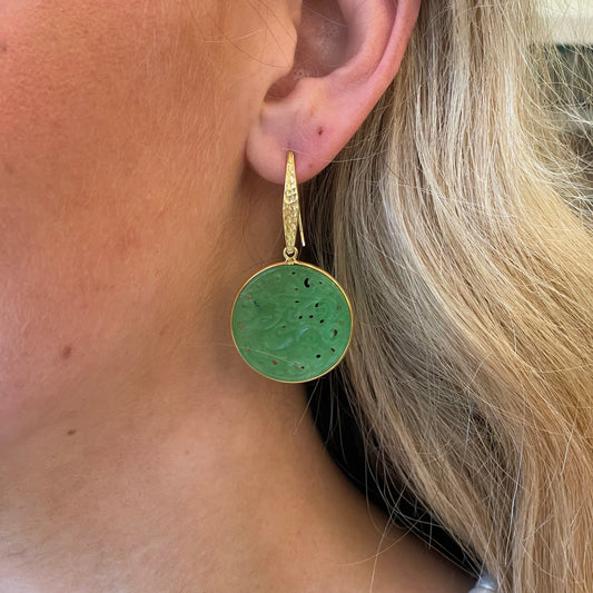 Bruno carved jade round hook drop earrings with intricate design and polished green jade, hanging from silver hooks.