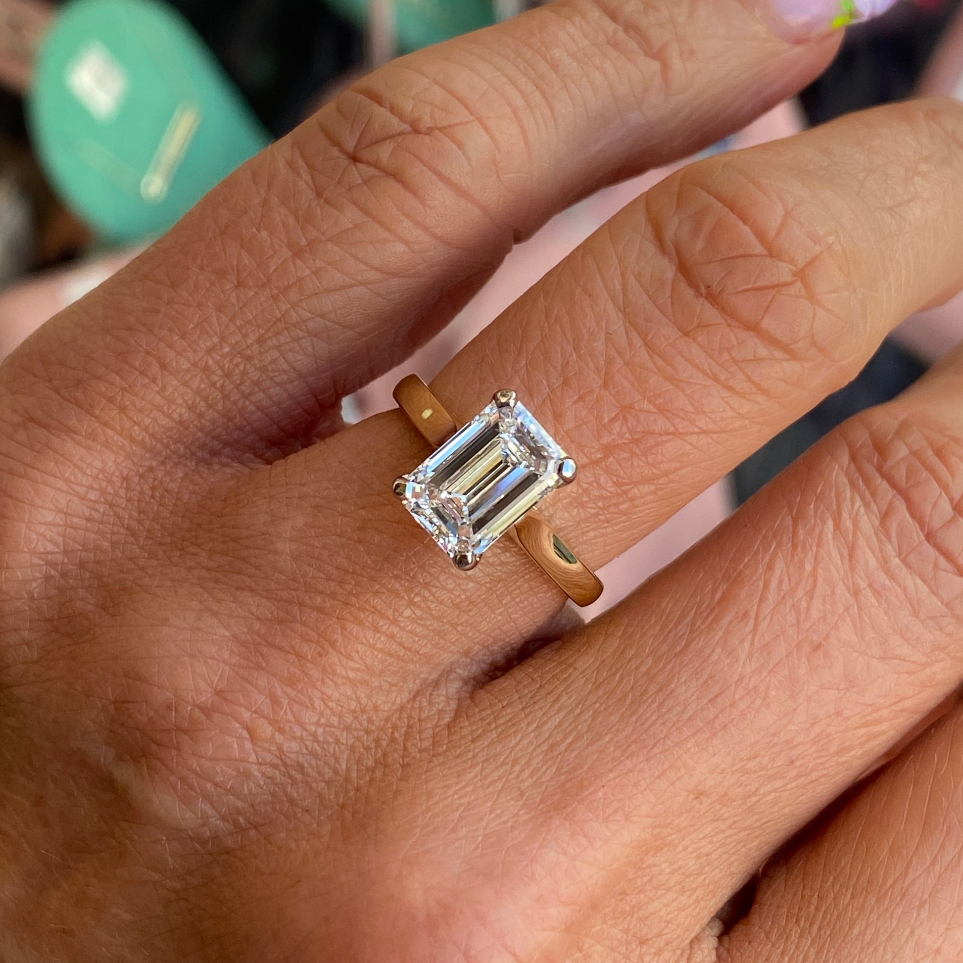 18ct gold emerald cut solitaire engagement ring with a 2.58ct certified lab diamond, featuring a sleek band and sparkling gemstone.