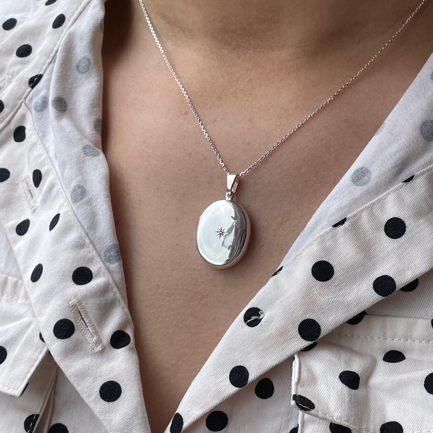 Silver diamond set oval locket necklace by Clandela featuring a polished silver finish and elegant oval shape.