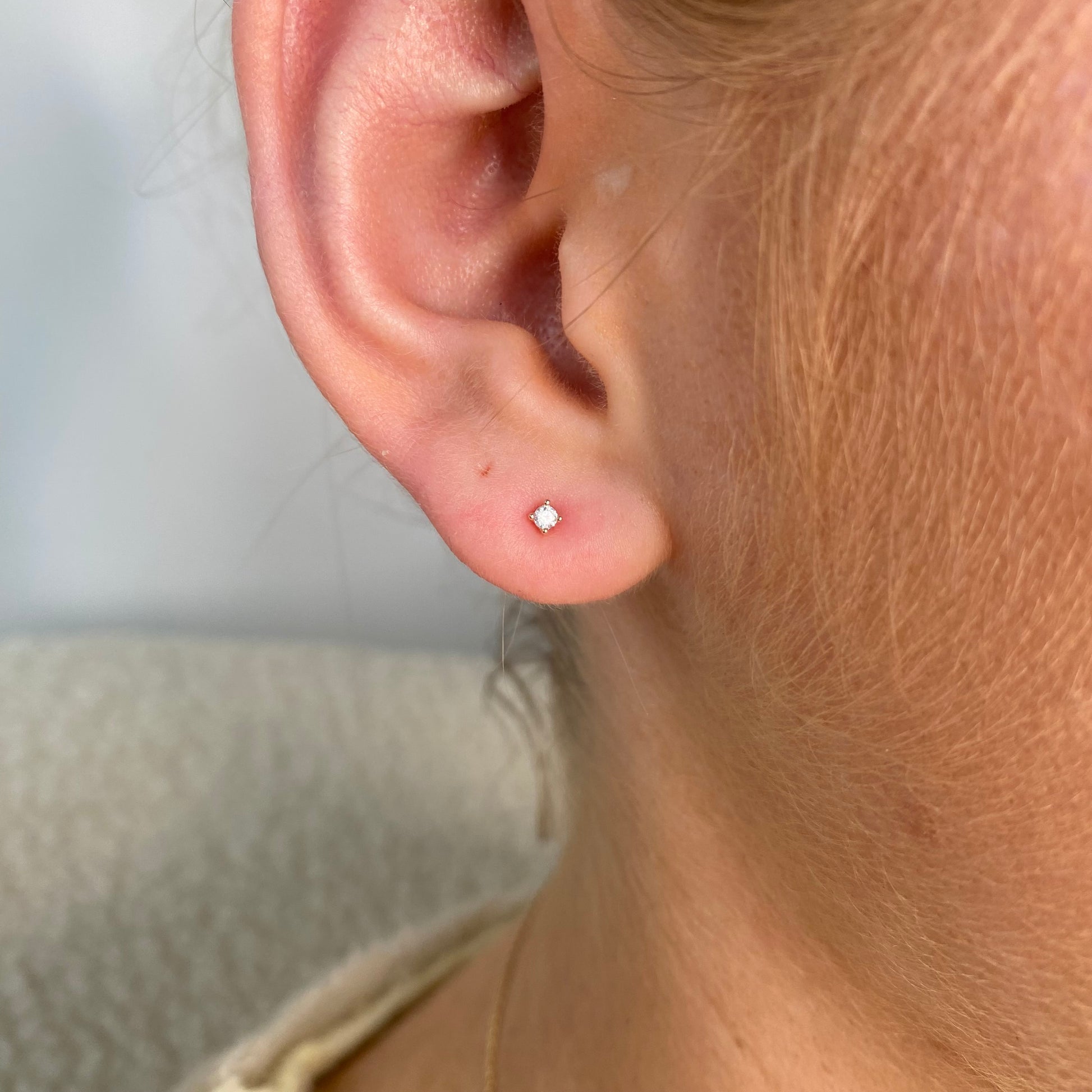 Sunshine 2mm CZ Nano Stud Earrings for kids by Comero, featuring sparkling cubic zirconia stones in a small, dainty design.