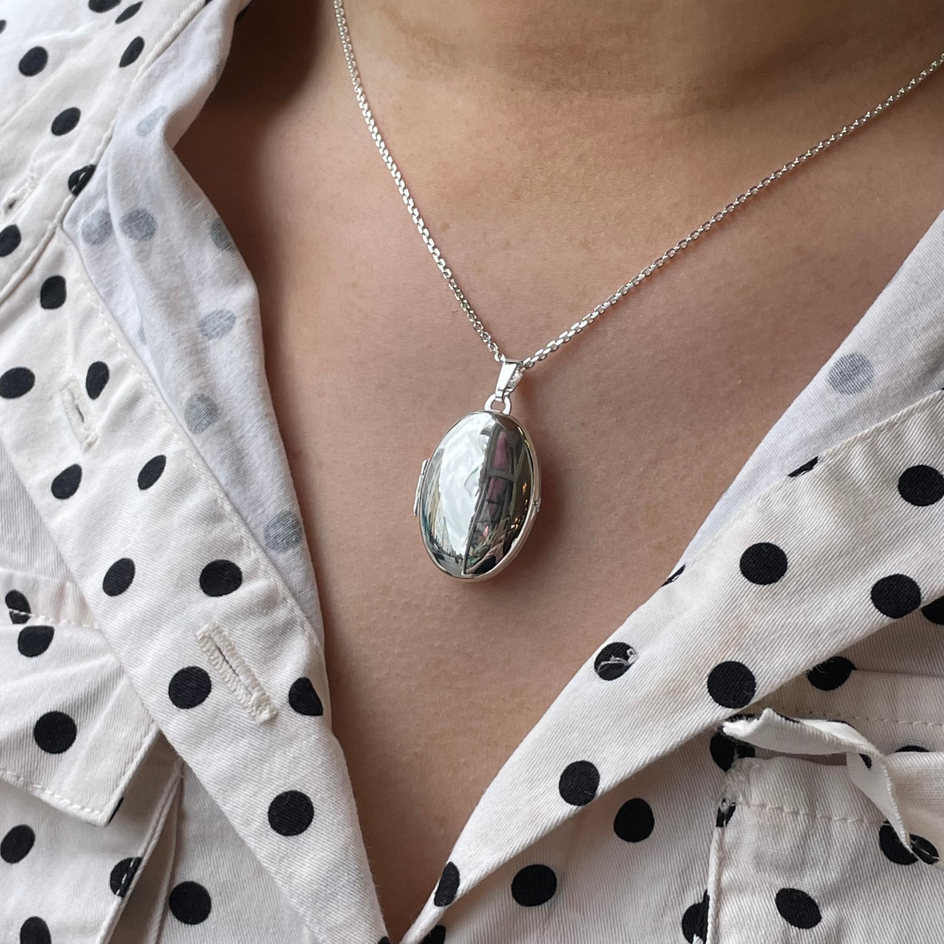 Silver Secret Heart Oval Locket Necklace by Clandela featuring a heart-shaped oval pendant on a delicate chain.