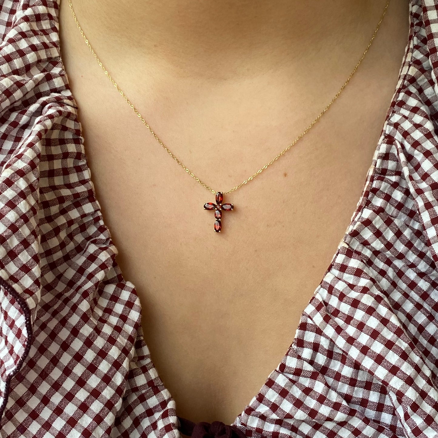 Gold Garnet Cross Necklace by Mark Milton featuring a 9ct gold chain with a garnet gemstone cross pendant.