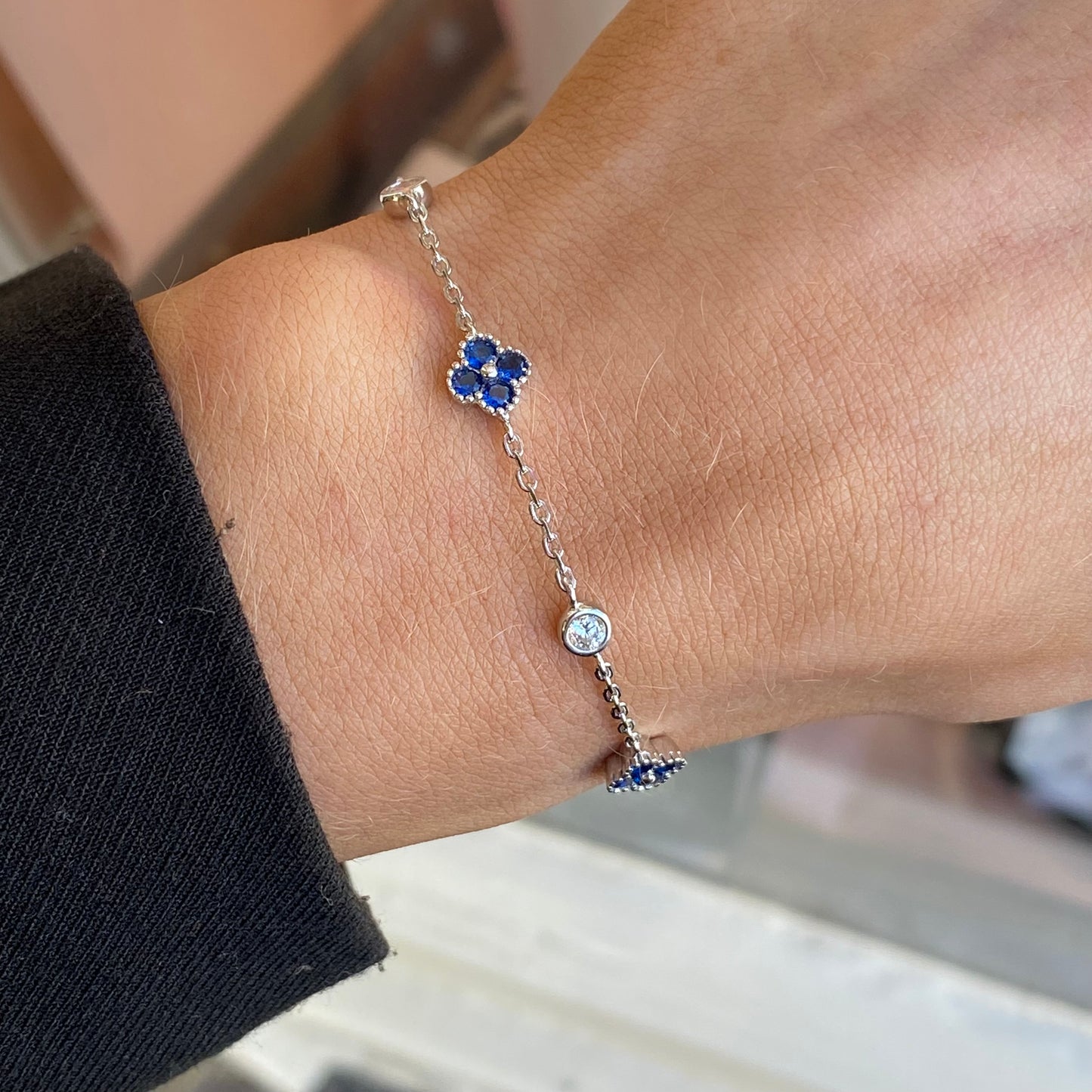 Silver CZ quatrefoil bracelet with sapphire blue accents by Insignia, featuring intricate design and sparkling gemstones.