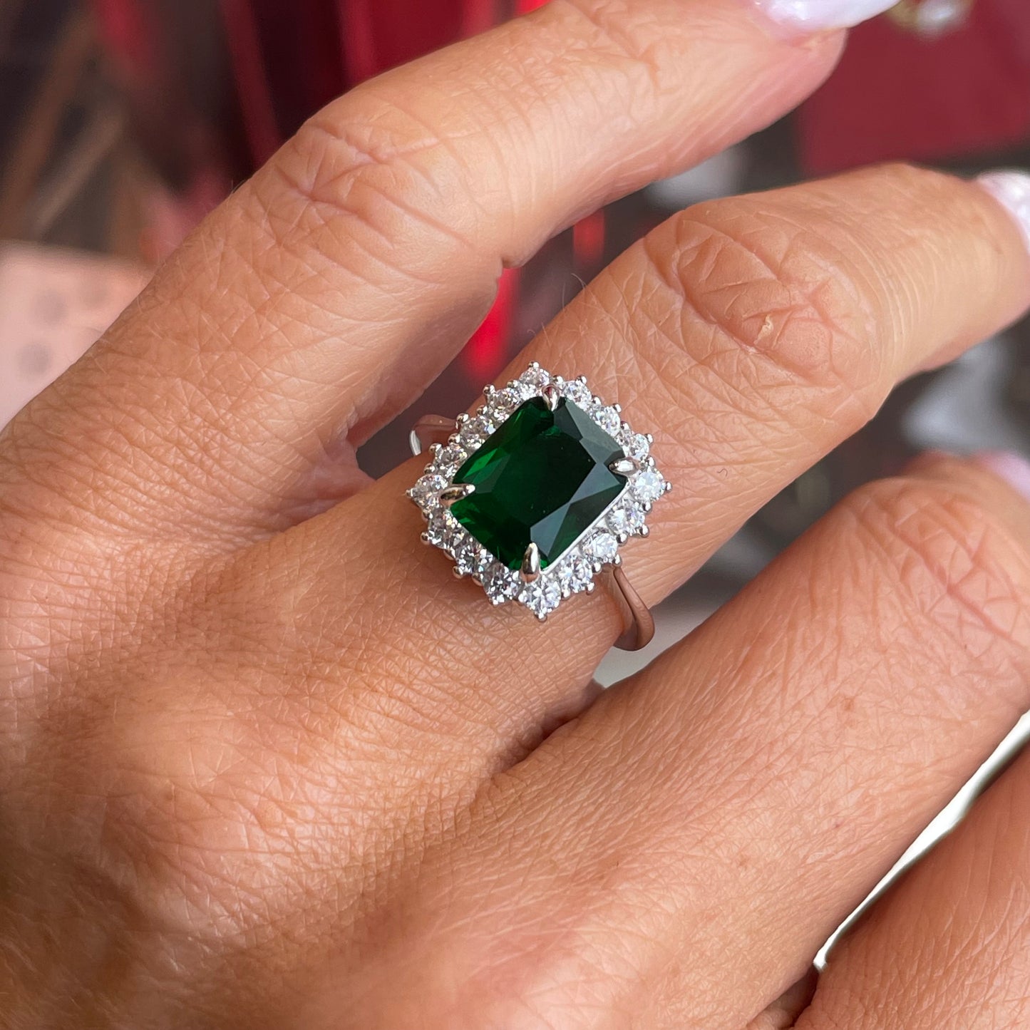Silver emerald green CZ statement ring with intricate design and sparkling gemstone, by Comero.