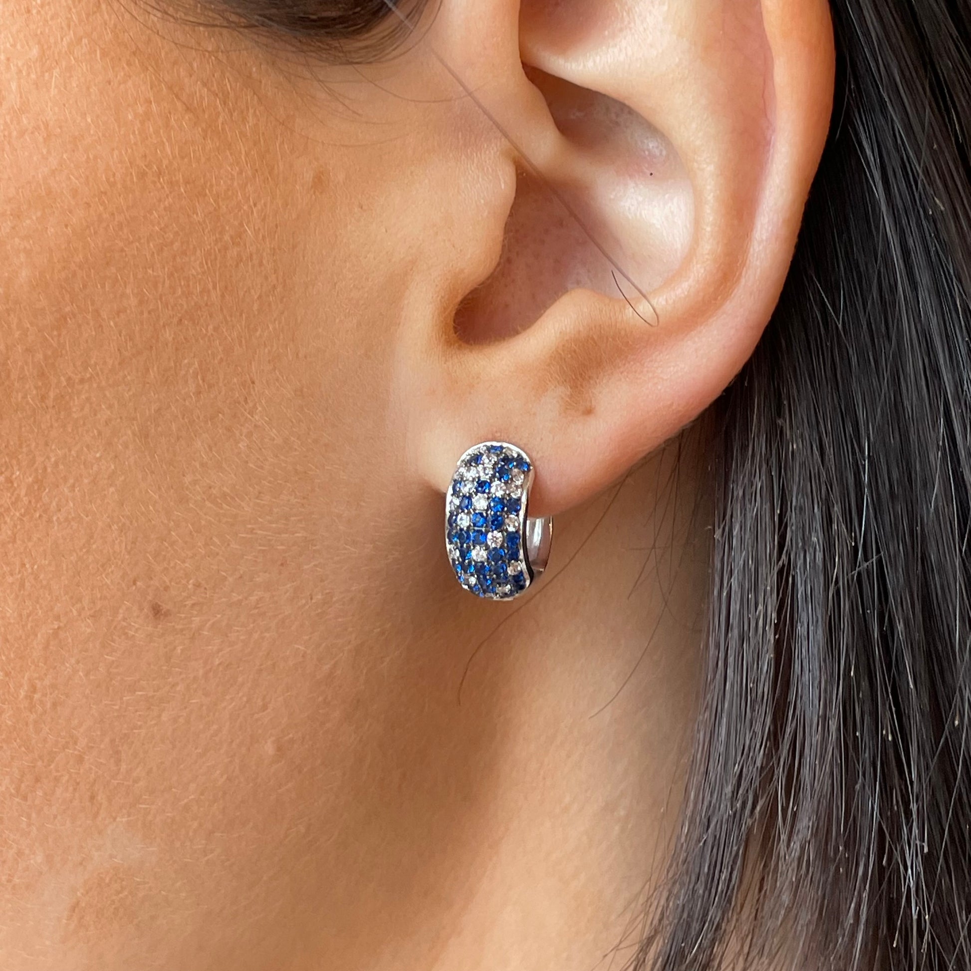 Silver blue ombre huggie hoop earrings by Comero, featuring small silver hoops with a blue gradient finish.