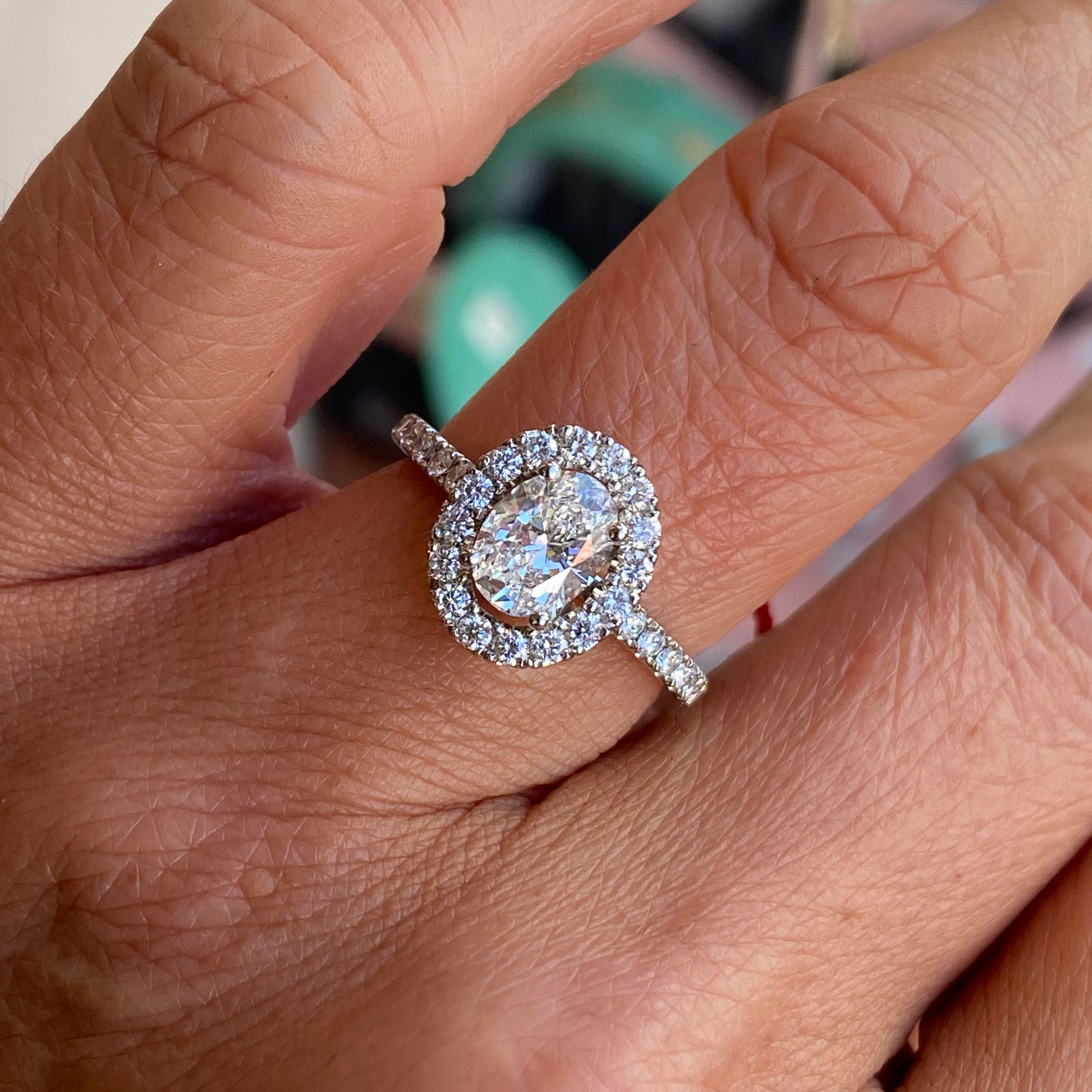 Domino platinum oval halo solitaire engagement ring with 1.00ct certified lab diamond, featuring a sleek band and intricate halo design.