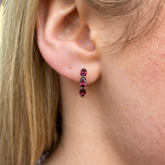 9ct gold garnet huggie hoop earrings by Mark Milton, 15mm size, featuring red garnet gemstones in a stylish hoop earring design.
