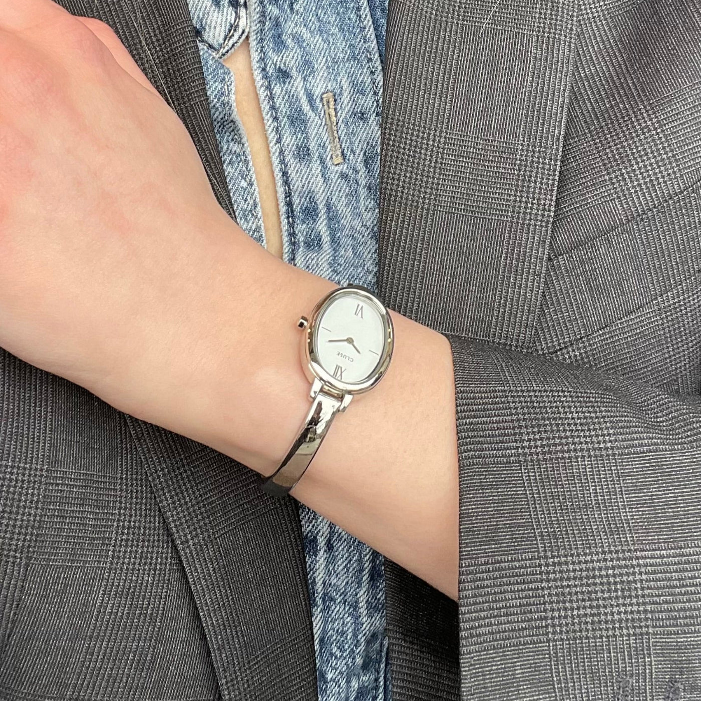 Silver CLUSE L'Ovale watch with a sleek oval face and minimalist design, featuring a silver strap and elegant time display.