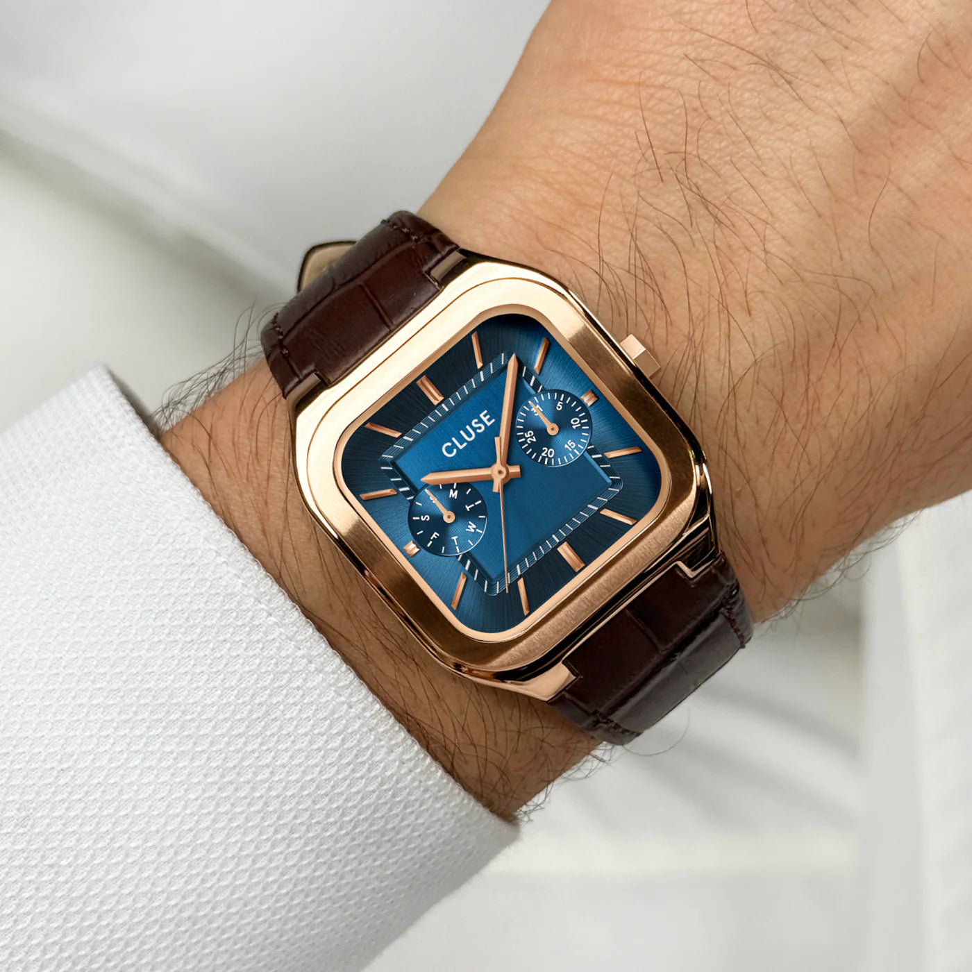 CLUSE Quadrus multifunction leather watch with rose gold and blue accents, featuring a sleek round dial and leather strap.
