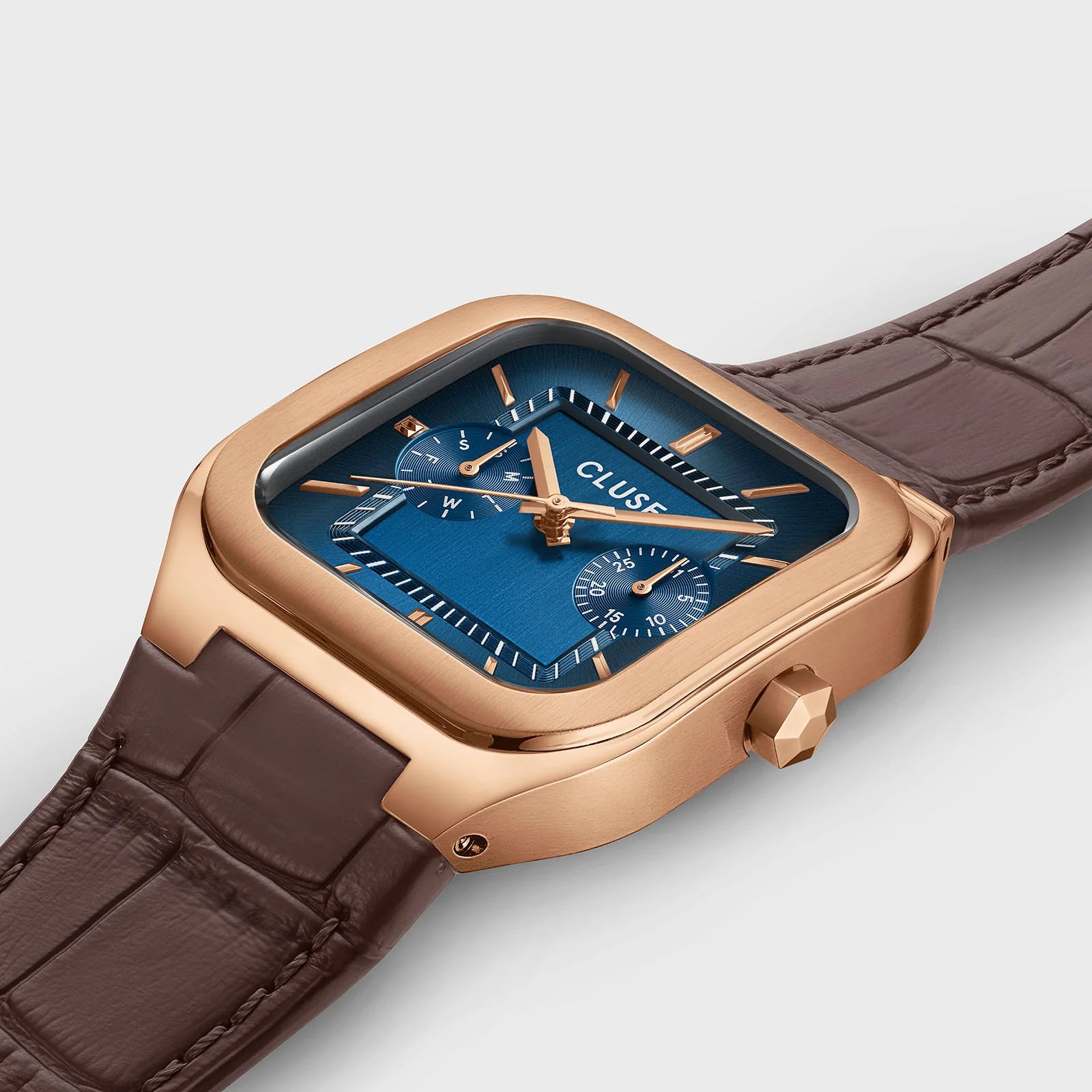 Close-up of CLUSE Quadrus multifunction leather watch with rose gold and blue accents, showing the detailed watch face and strap.