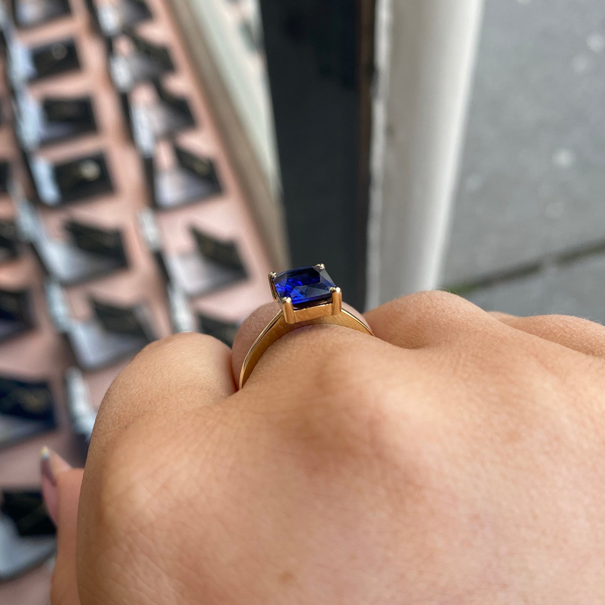 9ct gold created sapphire solitaire ring with a central blue sapphire gemstone set in a polished gold band.