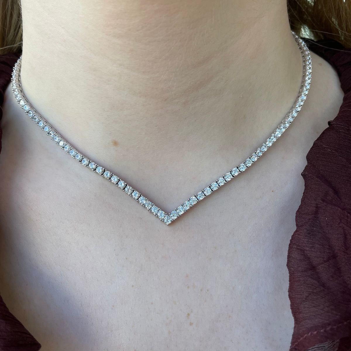 Silver CZ wishbone tennis necklace by Comero featuring sparkling cubic zirconia stones on a 42cm chain.