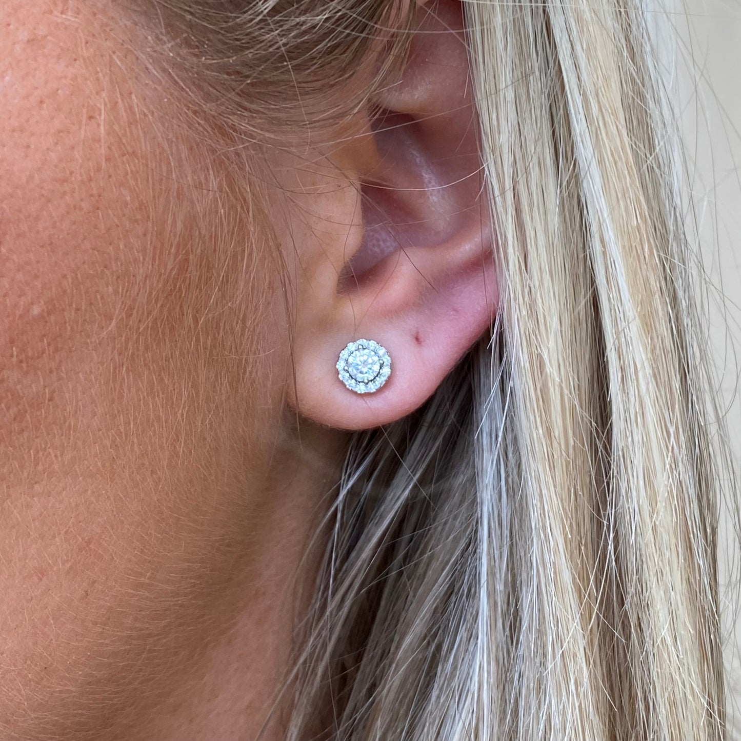 Silver round CZ halo stud earrings by Comero featuring sparkling cubic zirconia stones and a classic, elegant design.