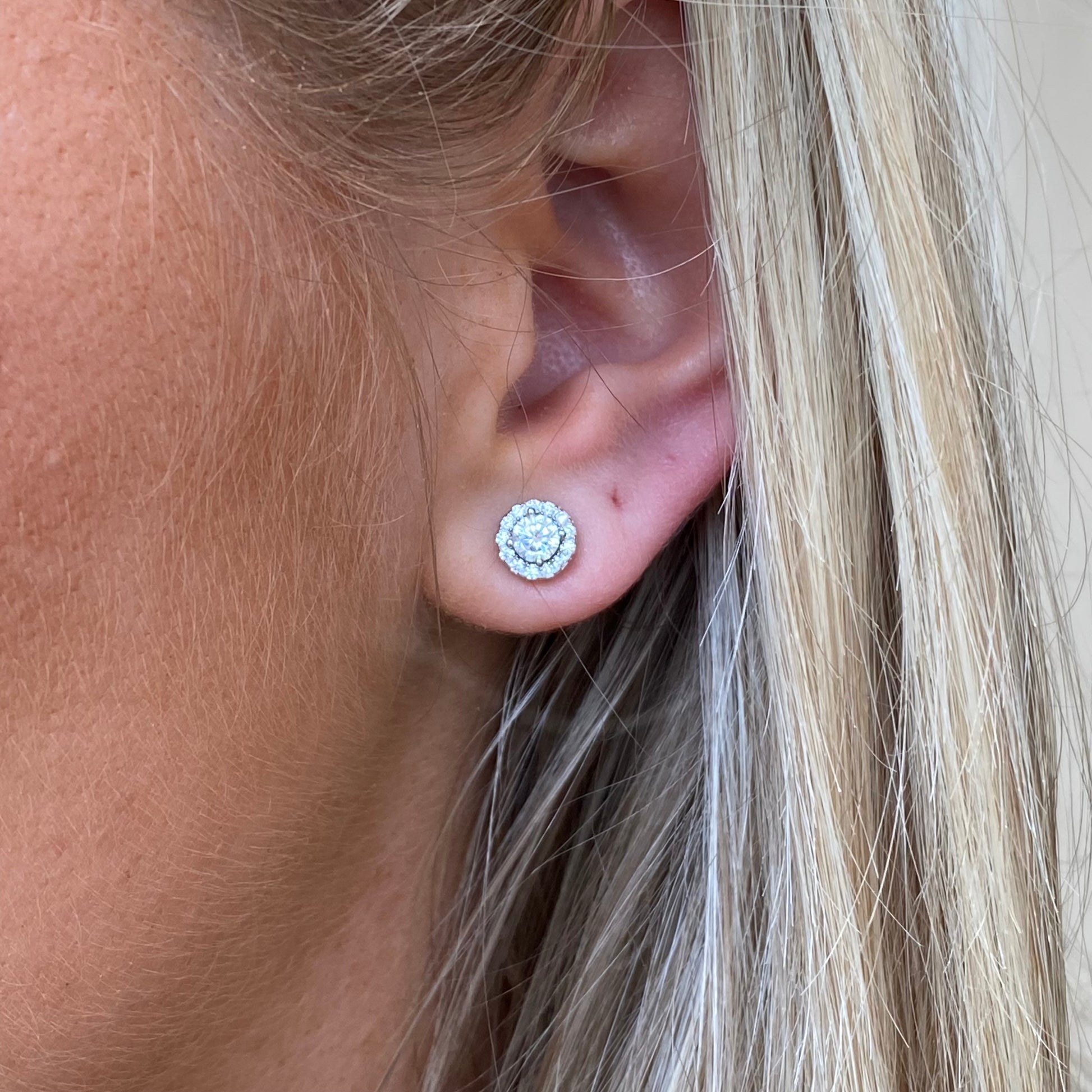 Silver round CZ halo stud earrings by Comero featuring sparkling cubic zirconia stones and a classic, elegant design.