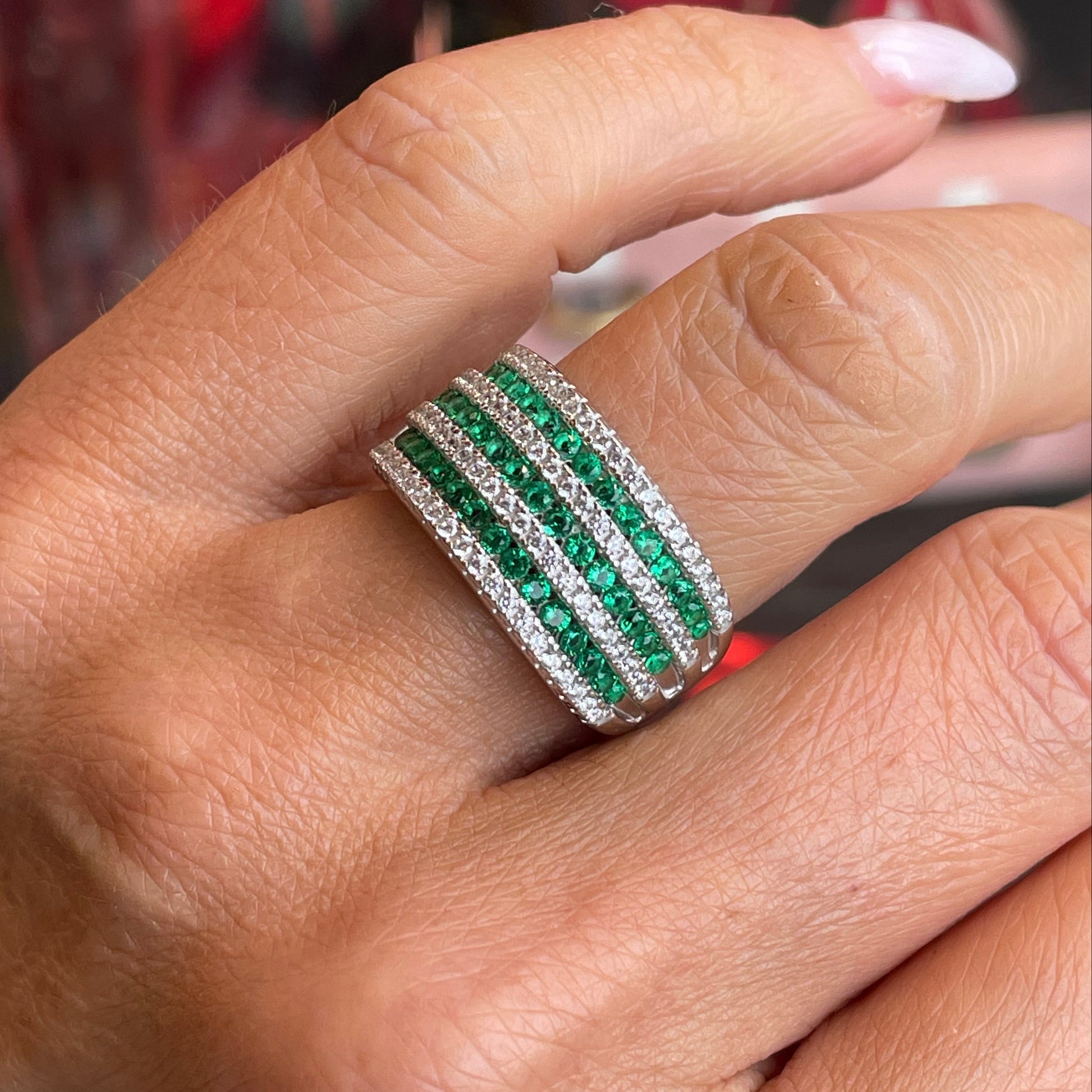 Silver CZ wide band ring with emerald green gemstone from Comero, showing the detailed design and shiny silver finish.