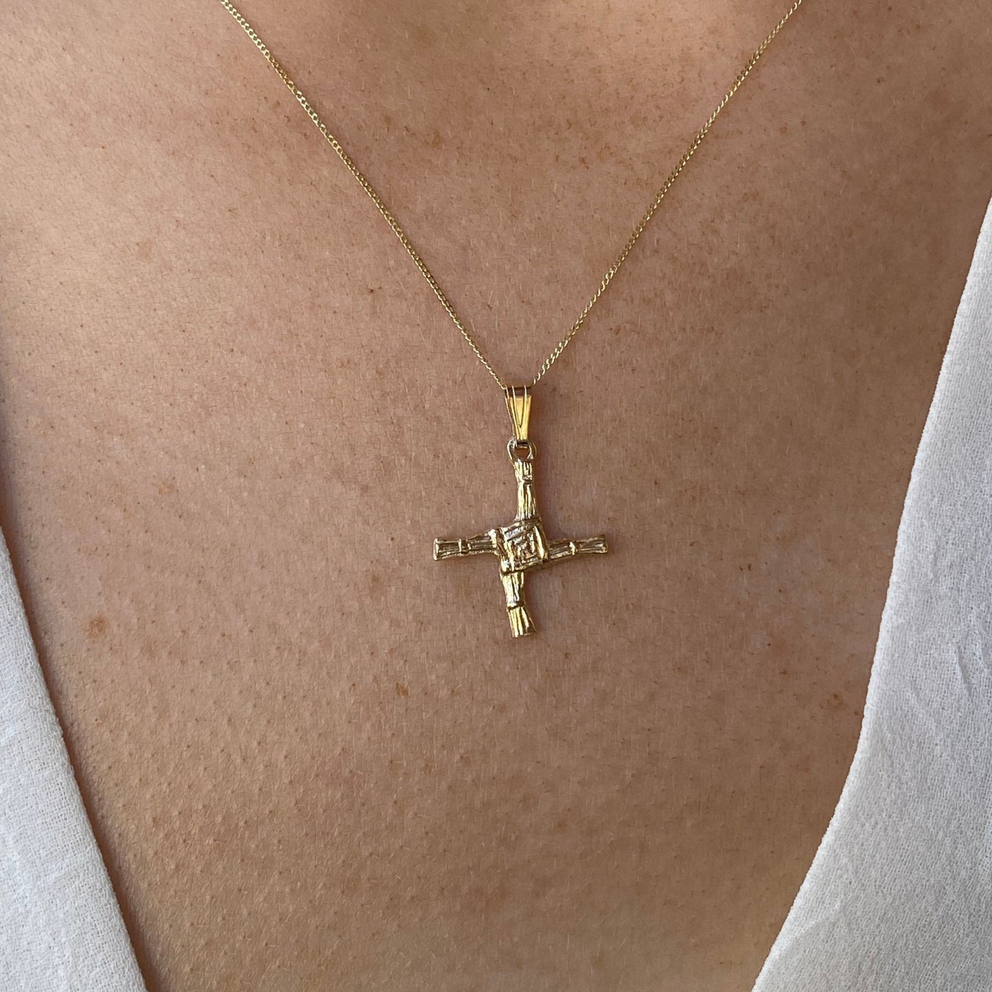 Facet 10ct gold St. Bridget's Cross necklace showcasing a delicate cross pendant on a fine chain.