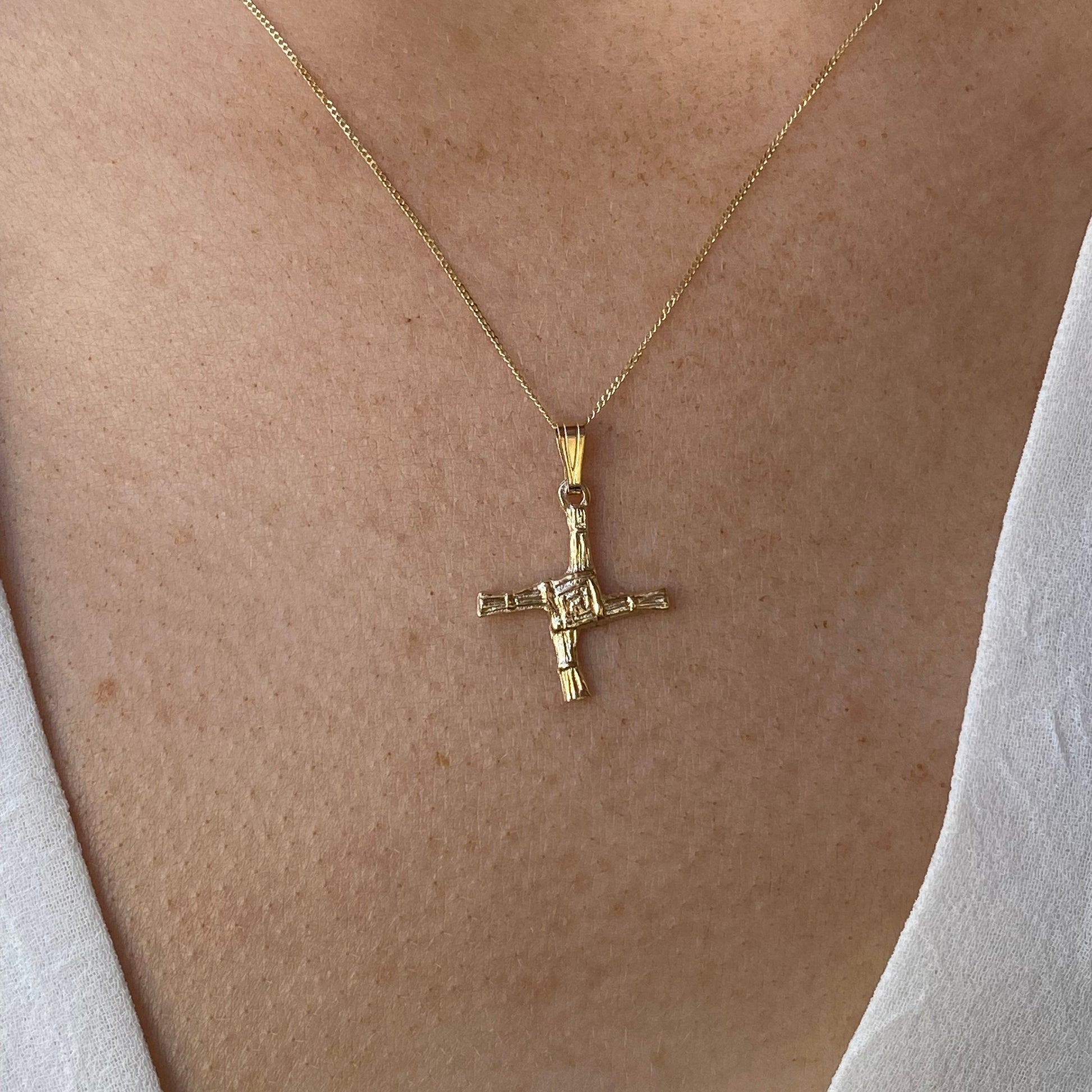 Facet 10ct gold St. Bridget's Cross necklace showcasing a delicate cross pendant on a fine chain.