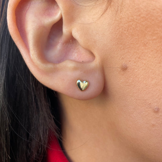 Sunshine Pretty Heart Stud Earrings by Comero, gold-toned earrings with heart-shaped design, close-up view showing shiny finish.