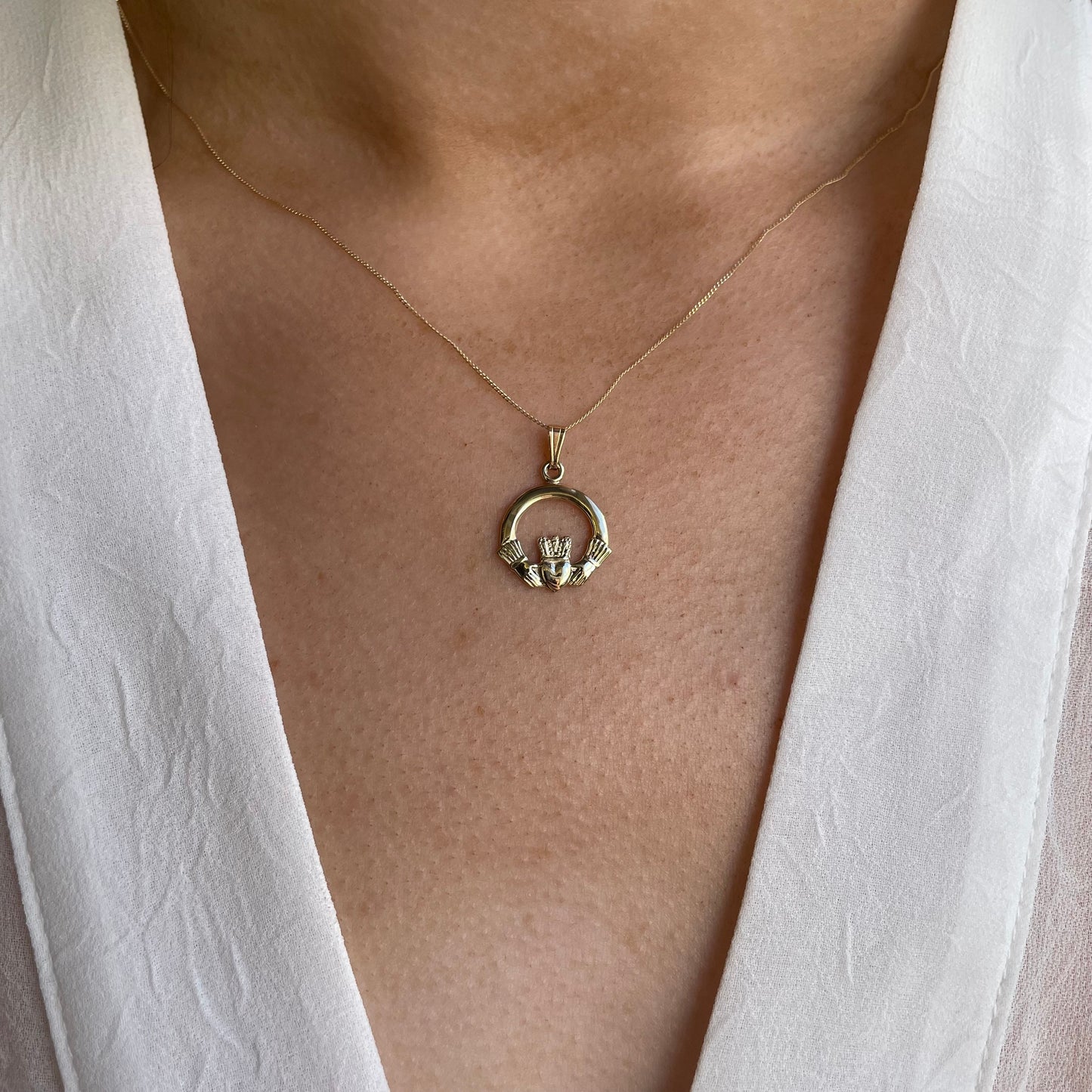 Gold Claddagh necklace by Facet, large 10ct gold pendant with traditional heart, hands, and crown design on a delicate chain.