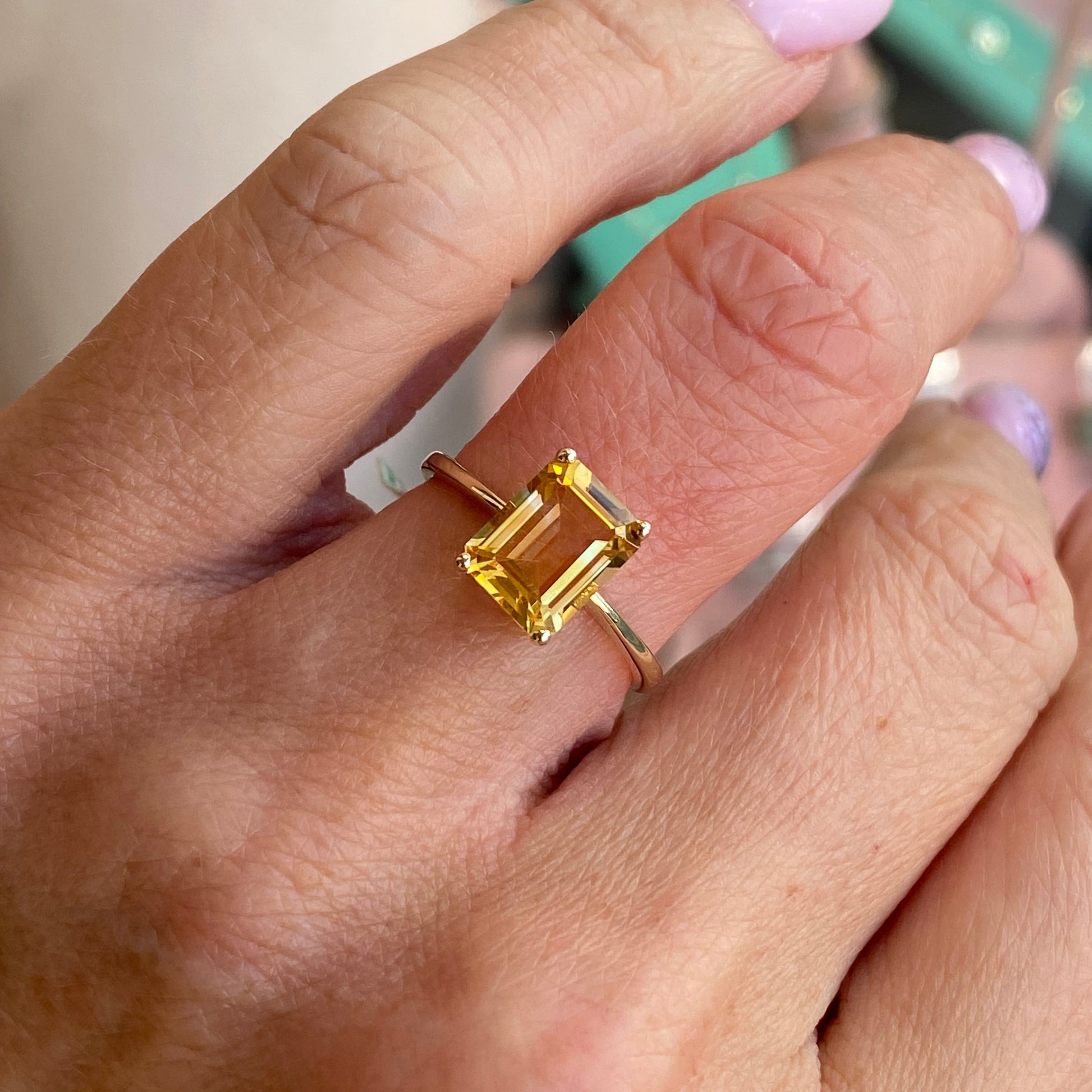 Insignia 9ct gold emerald cut citrine ring showcasing a vibrant yellow gemstone set in a sleek gold band.