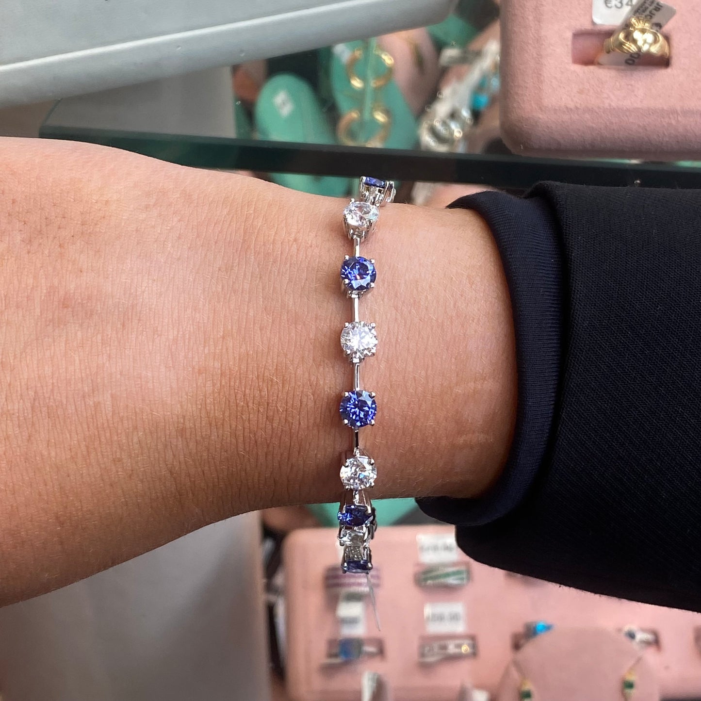 Silver CZ tennis bracelet with tanzanite blue gemstones by Insignia, showcasing sparkling stones and elegant design.