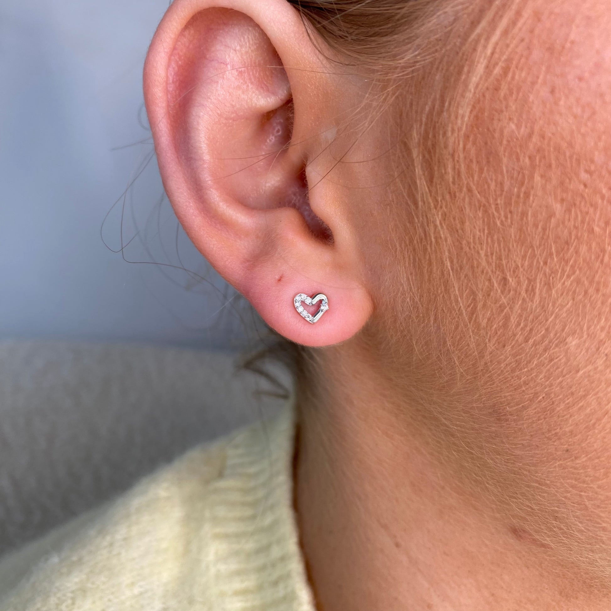 Silver half set CZ open heart kid's stud earrings by Comero, featuring sparkling cubic zirconia and open heart design.