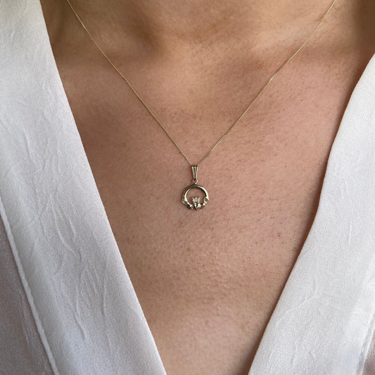 Mini 10ct gold Claddagh necklace by Facet featuring a detailed heart and hands pendant on a delicate chain.