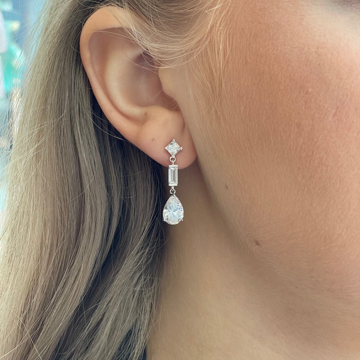 Silver C-Flawless Pear CZ Drop Earrings by Insignia featuring sparkling pear-shaped cubic zirconia drops.