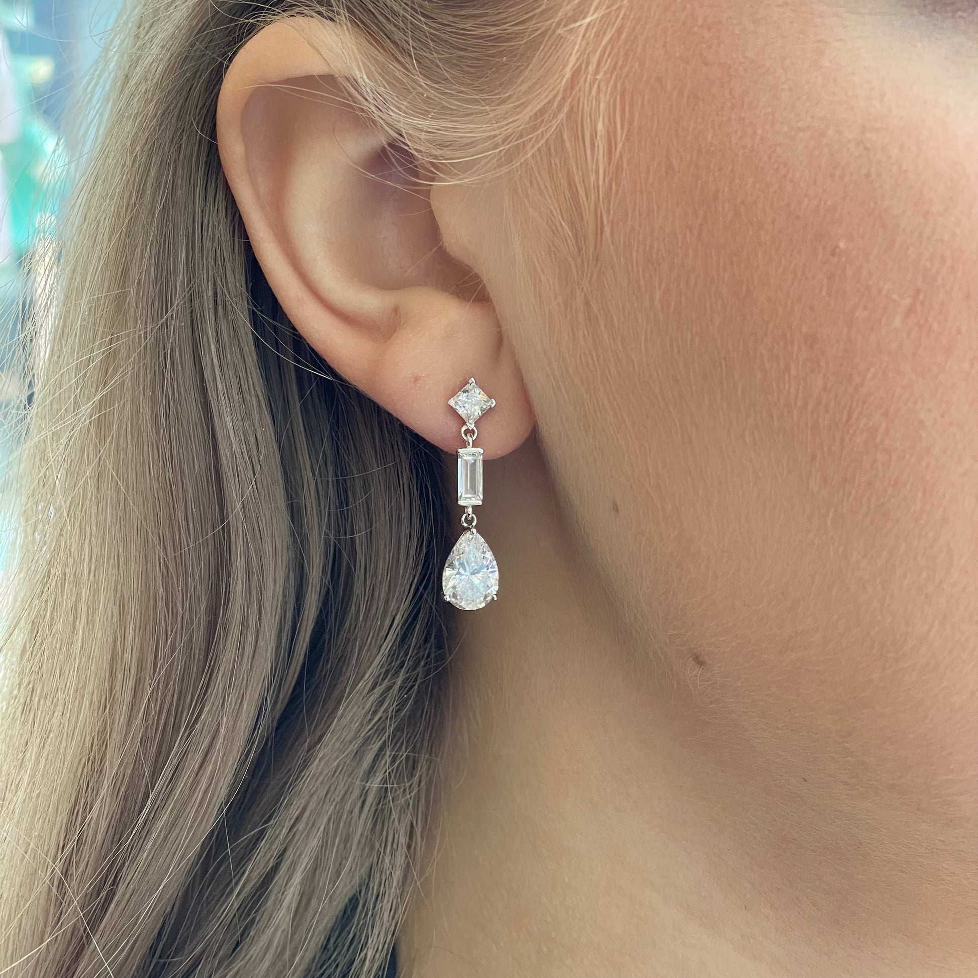 Silver C-Flawless Pear CZ Drop Earrings by Insignia featuring sparkling pear-shaped cubic zirconia drops.