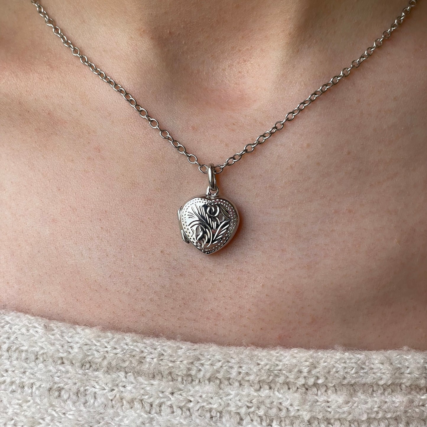 Silver engraved heart locket necklace with chain, featuring intricate design and polished finish, by Insignia.