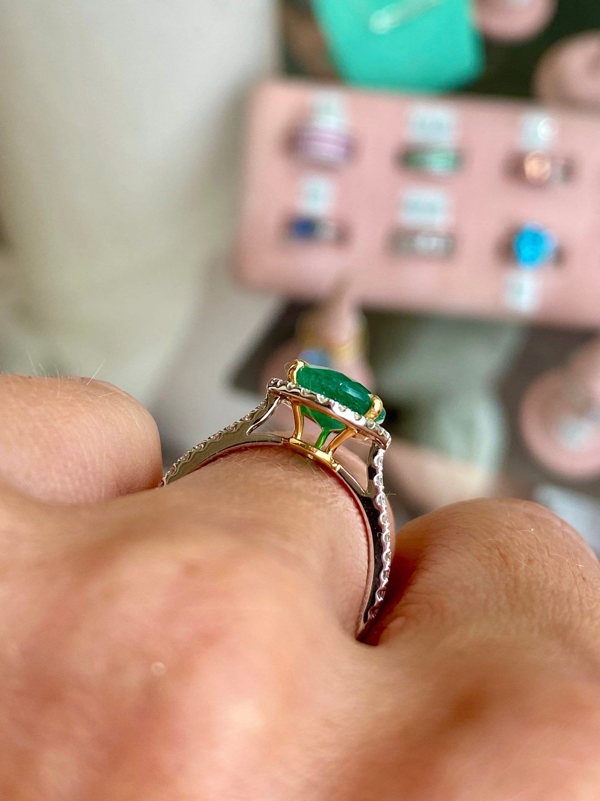Herbert platinum emerald and diamond pear-shaped ring showcasing a central emerald surrounded by sparkling diamonds.
