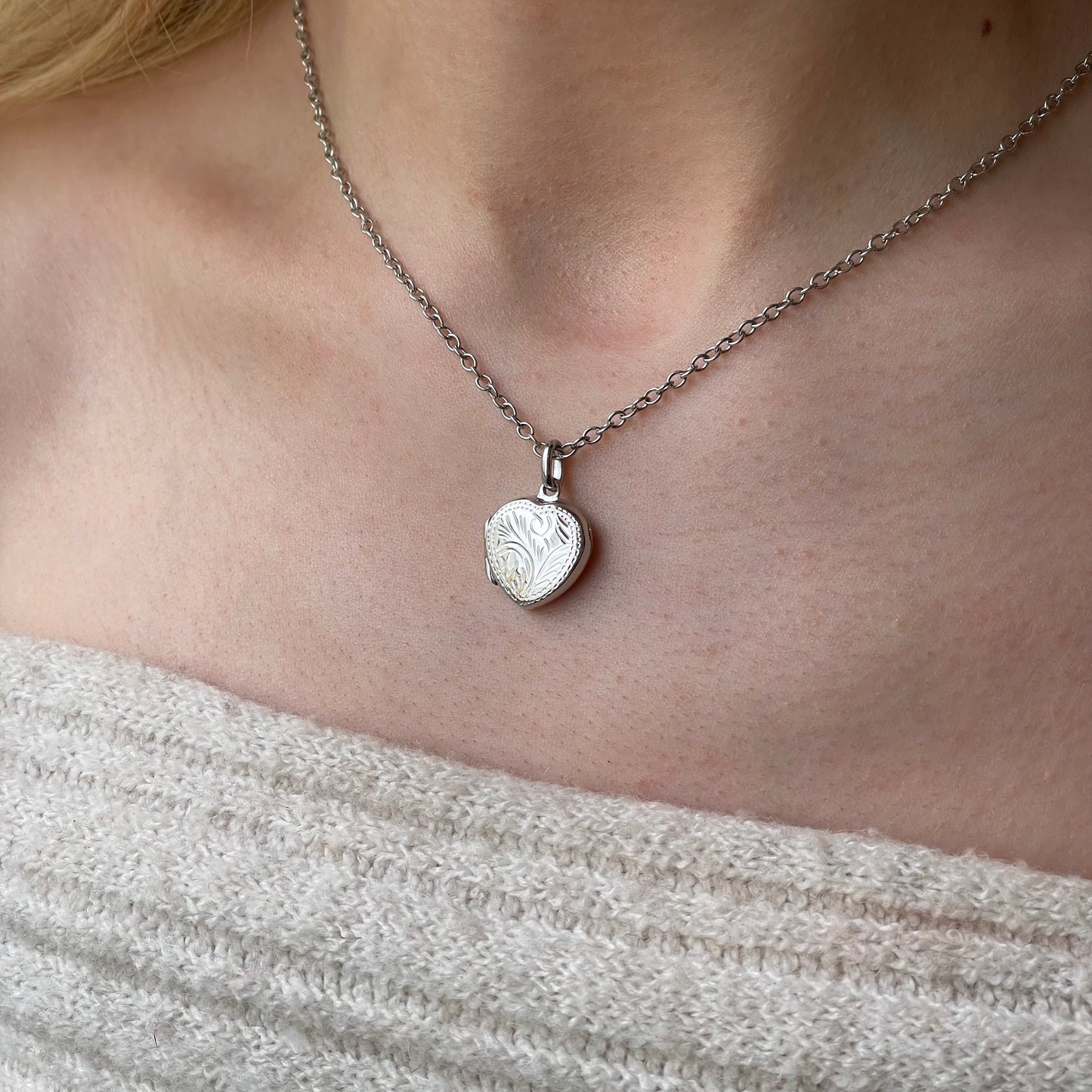 Silver engraved heart locket necklace with chain by Insignia, featuring detailed heart-shaped pendant with intricate engravings.