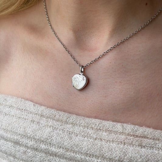 Silver engraved heart locket necklace with chain by Insignia, featuring detailed heart-shaped pendant with intricate engravings.