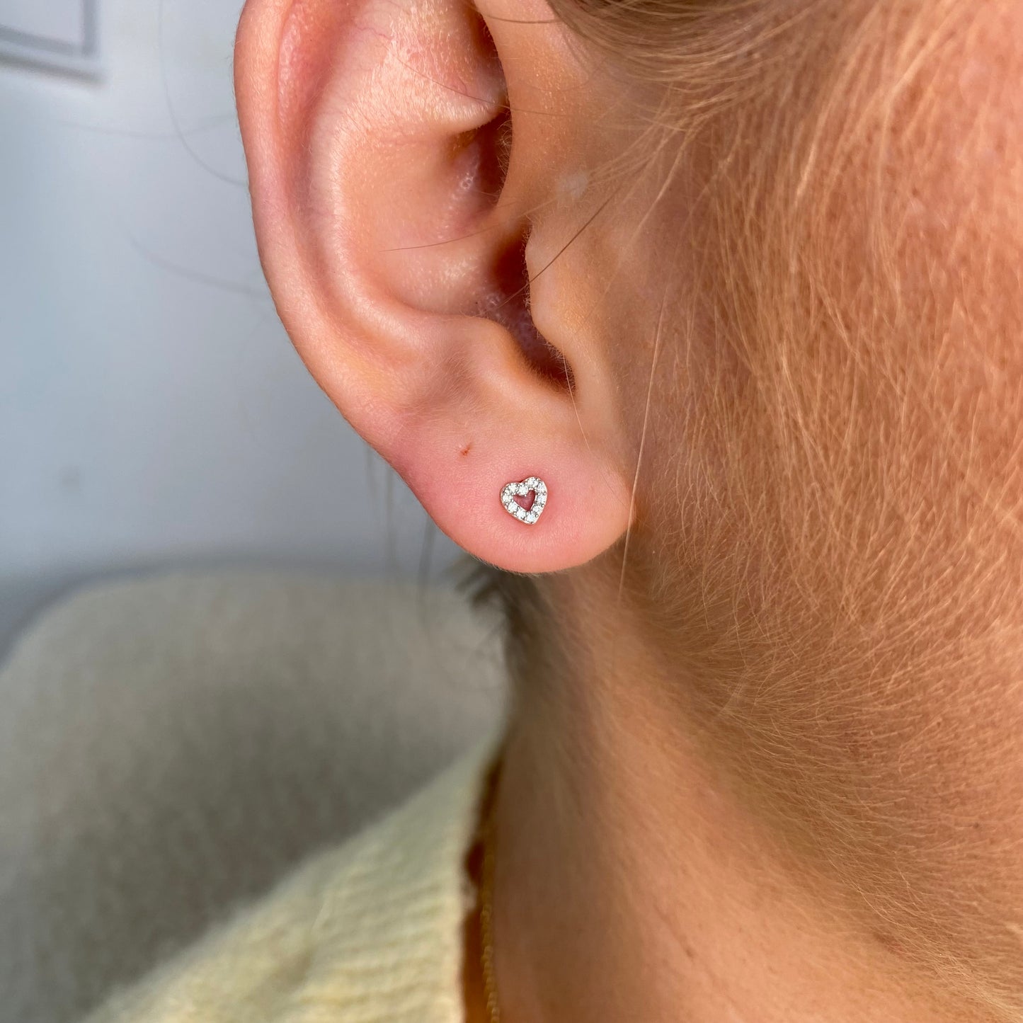 Silver tiny CZ open heart kid's stud earrings by Comero, featuring small sparkling cubic zirconia and open heart design.
