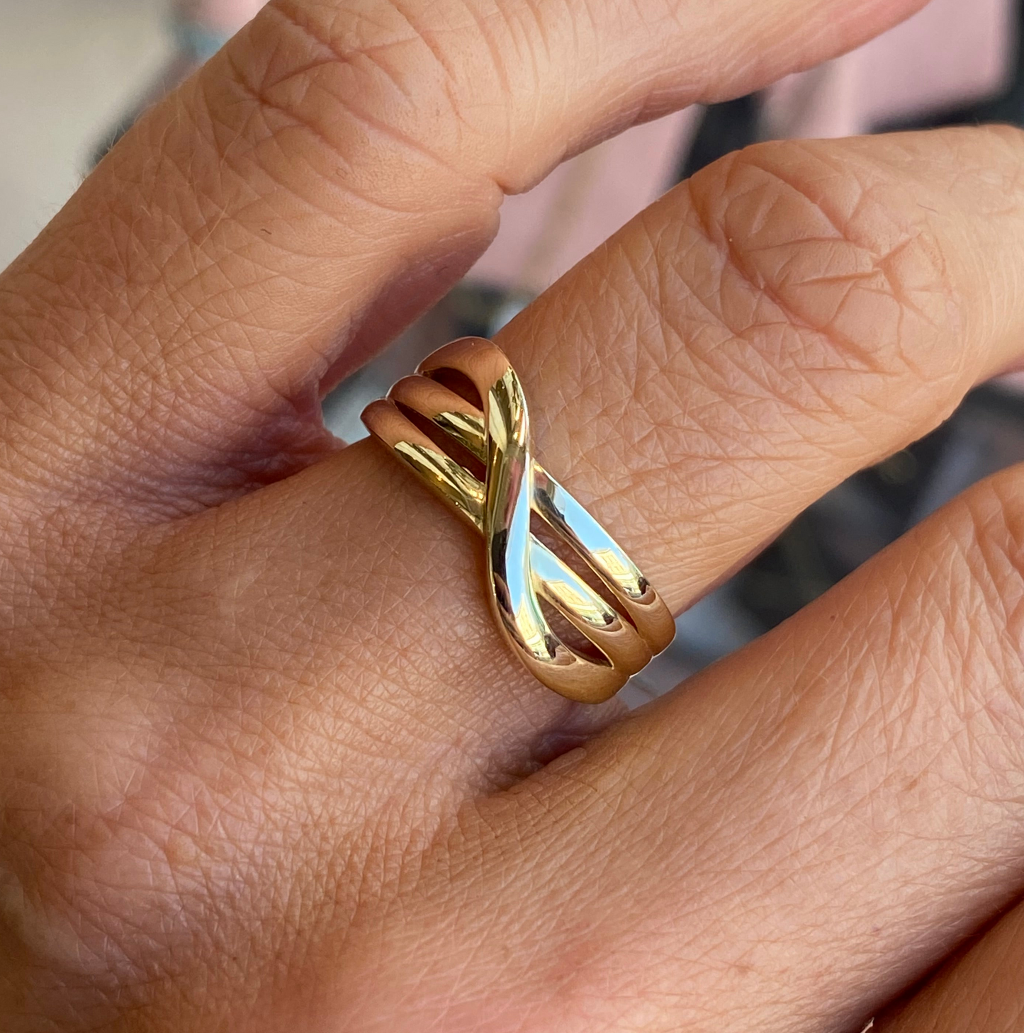 9ct gold crossover ring featuring a sleek design, crafted by NJO, showcased on a neutral background.