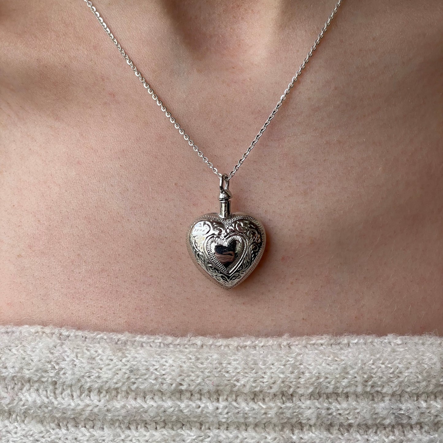Silver engraved heart ash locket necklace with detailed design, featuring a secure clasp and polished finish, by Insignia.
