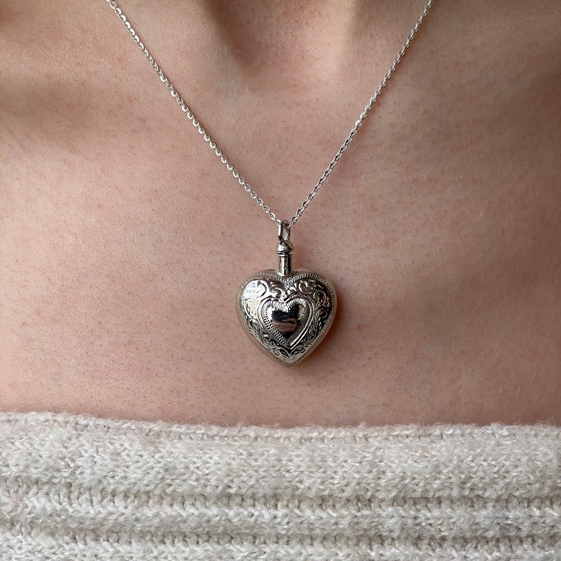 Silver engraved heart ash locket necklace with detailed design, featuring a secure clasp and polished finish, by Insignia.