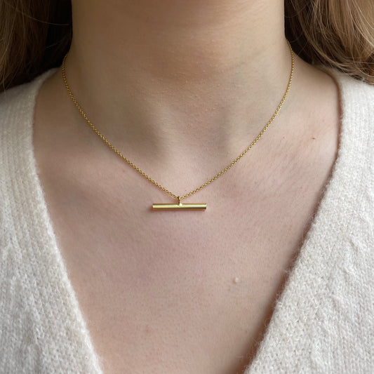 CME Sunshine T-Bar Necklace with gold-tone chain and sun-shaped pendant, stylish jewelry accessory for women.