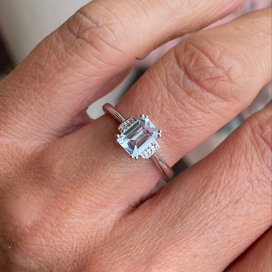 9ct white gold aquamarine and diamond ring by Mark Milton, featuring a central aquamarine gemstone and diamond accents.