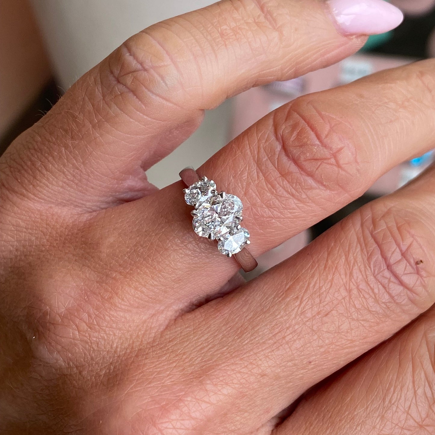 TCA platinum oval trilogy engagement ring with 1.59ct lab-certified diamonds, showcasing a sleek and elegant design.