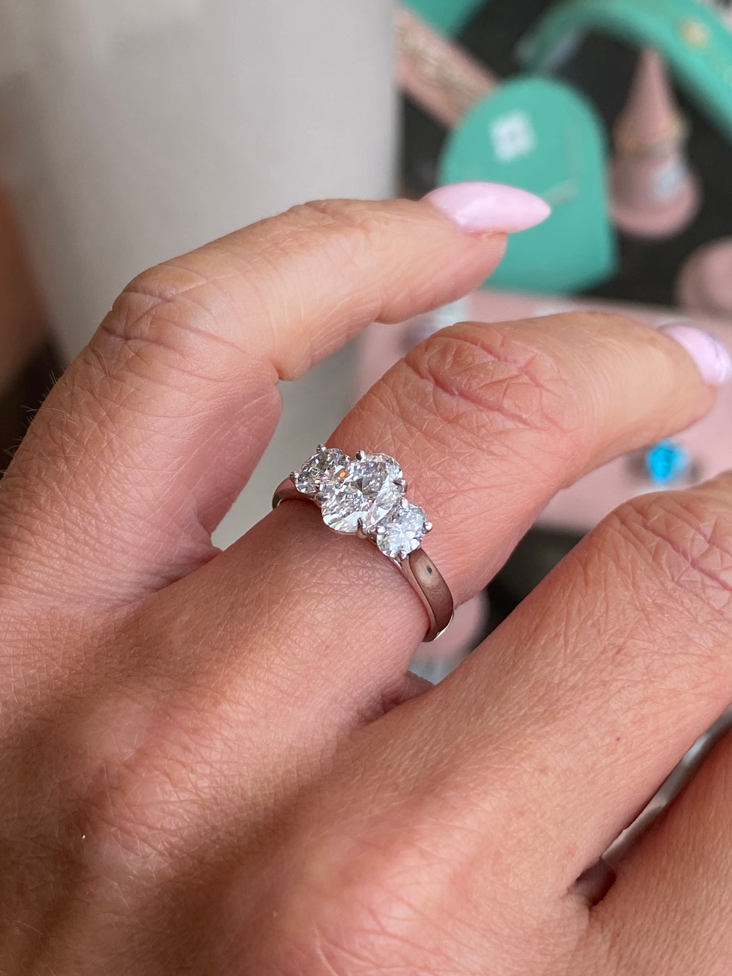 Platinum oval trilogy engagement ring by TCA with lab-certified 1.59ct diamond, showcasing a stunning three-stone design.
